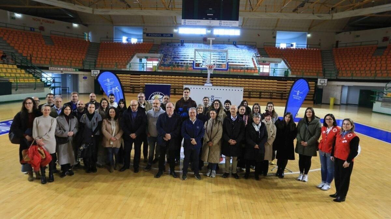 El presidente de la Diputación, Luis Menor, y el del COB, Eduardo Villar, rodeados por representantes de: ASPANAS, As Burgas, ADO, AIXIÑA, Cruz Vermella, Provivenda, Residencia Os Milagros, APSOU, Trascos, Meniños, ONCE Ourense, Fundación Secretariado Xitano, Fundación Diagrama (centro de menores Montealegre), Asociación Ginso (centro de menores Monteledo e Montefiz) y Cáritas Ourense, además del entrenador Moncho López y el jugador Samu Rodríguez.