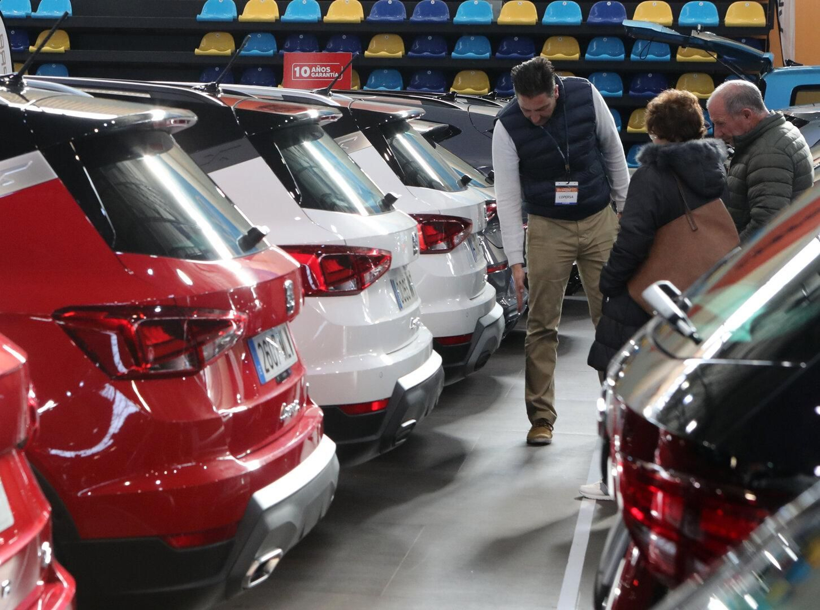 Uno de los trabajadores muestra con detalle la parte trasera de uno de los coches expuestos en el salón.