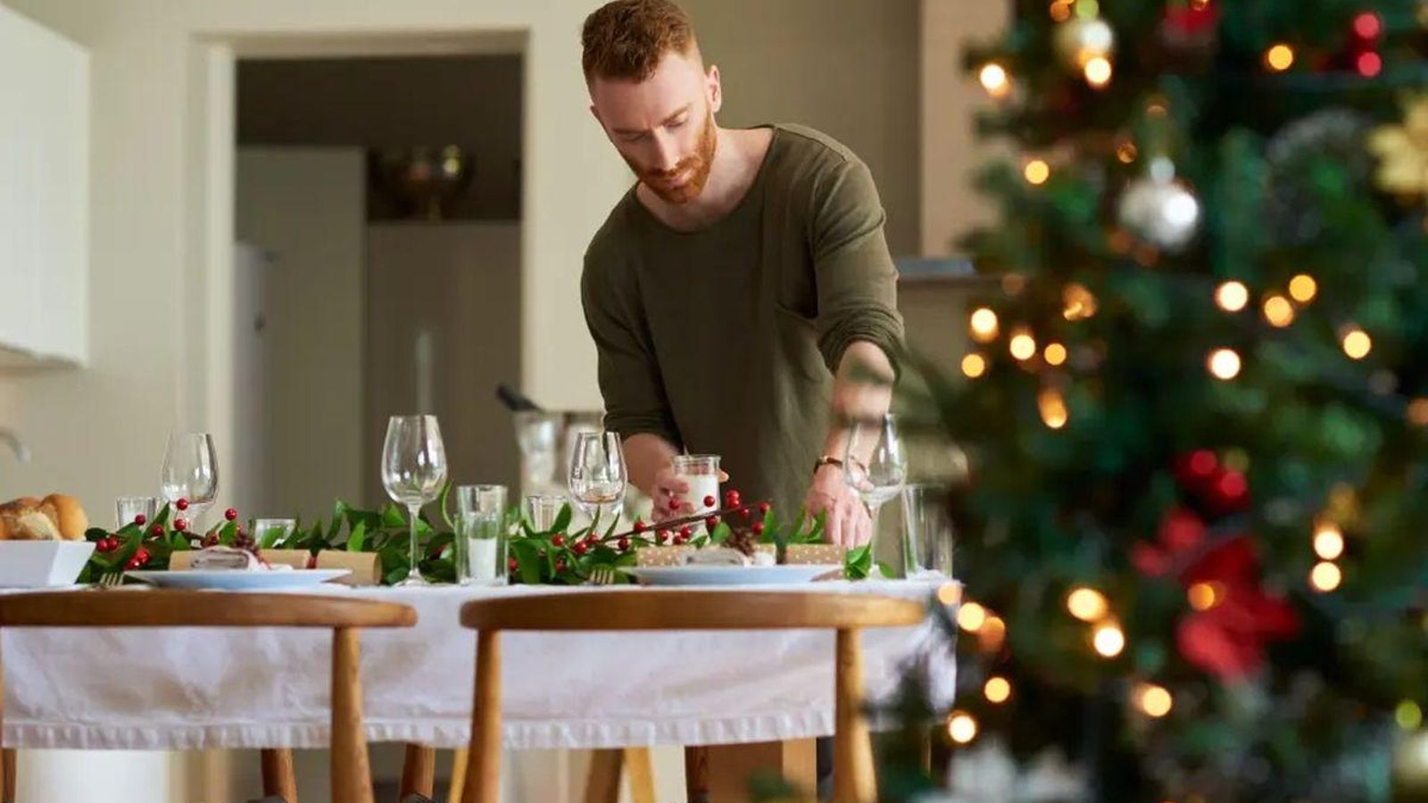 Un hombre prepara la mesa para una de las cenas de las fechas finales del año.