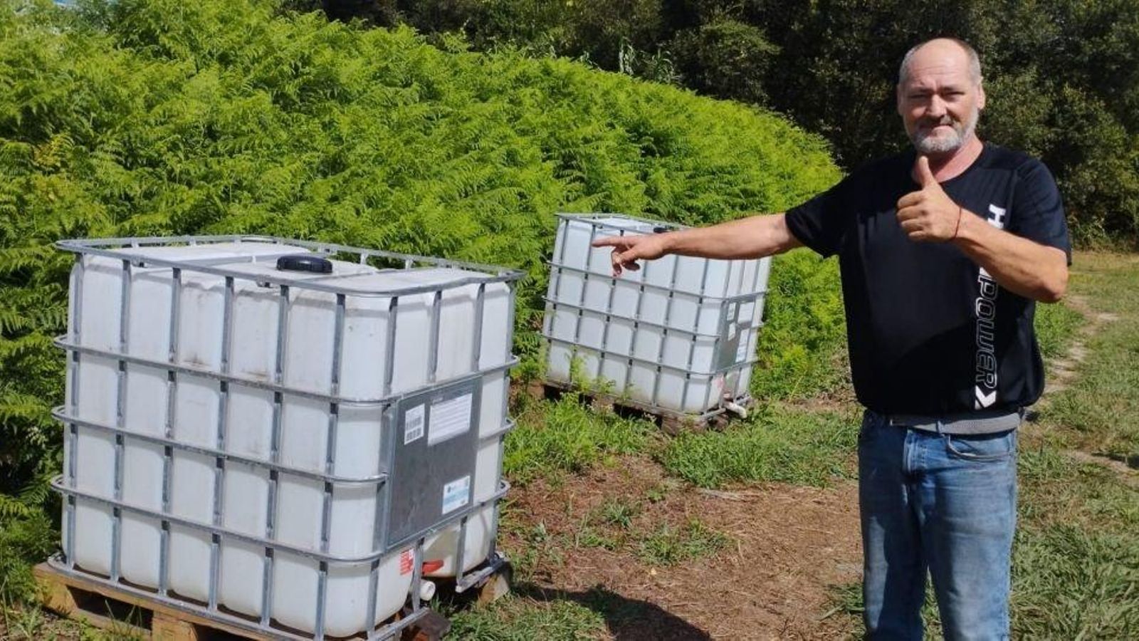 Un feriante mostrando los depósitos instalados por el Concello.