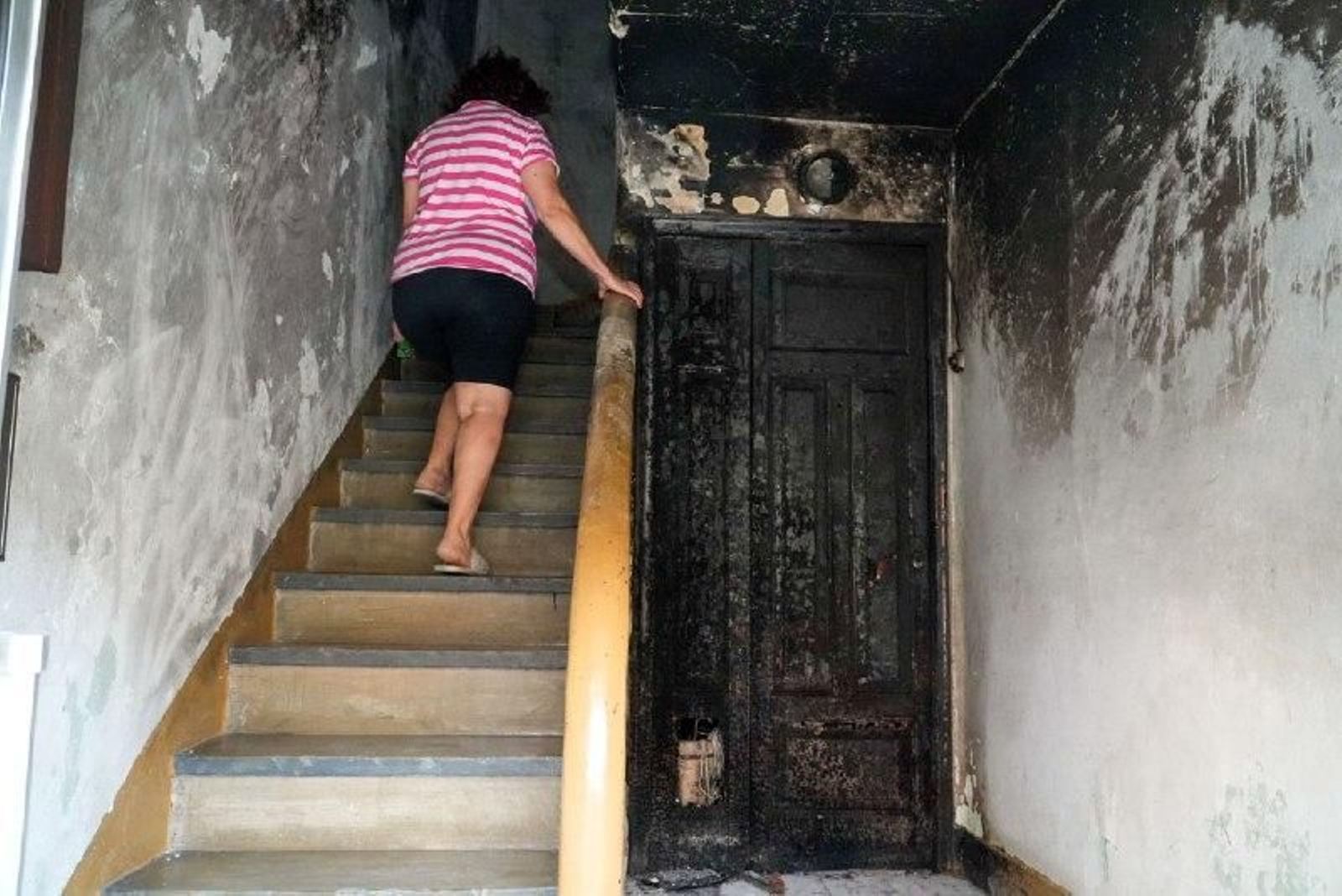 Una vecina, en el interior del edificio, dañado por el humo.