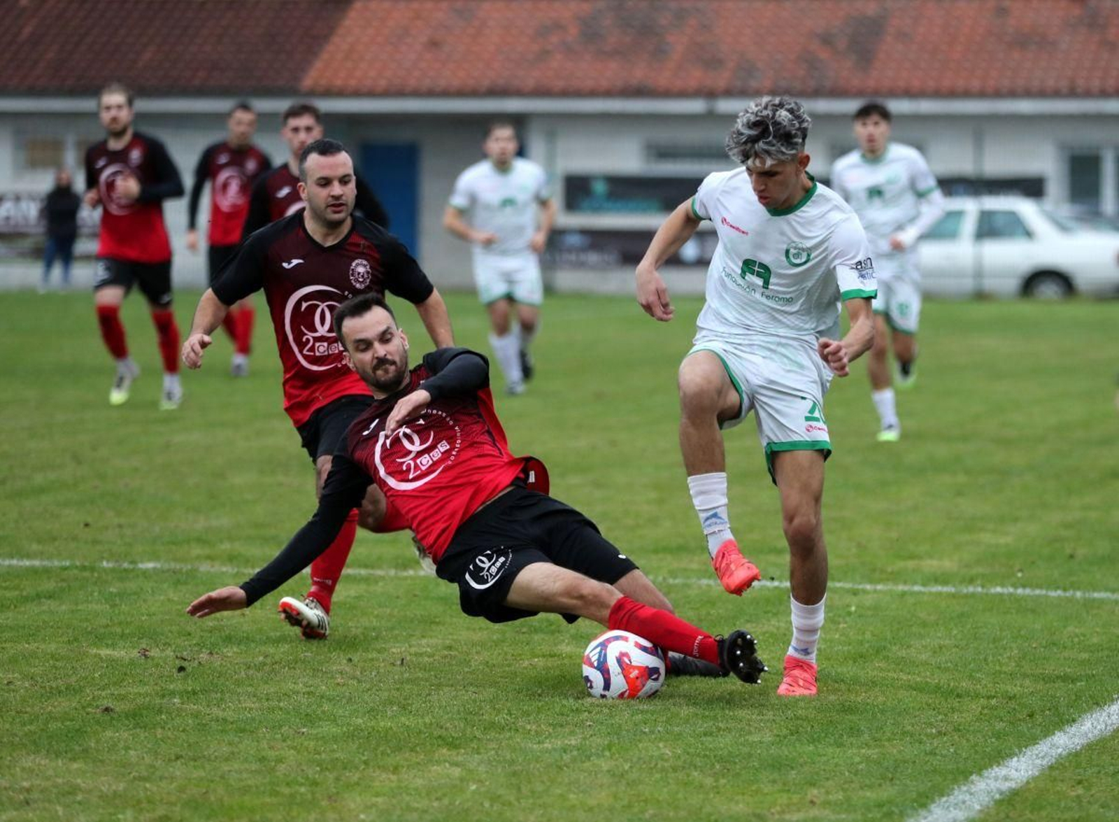 El defensa Samu, del Brollón, se arroja al piso para cortar el avance de Imrane, del Nogueira.
