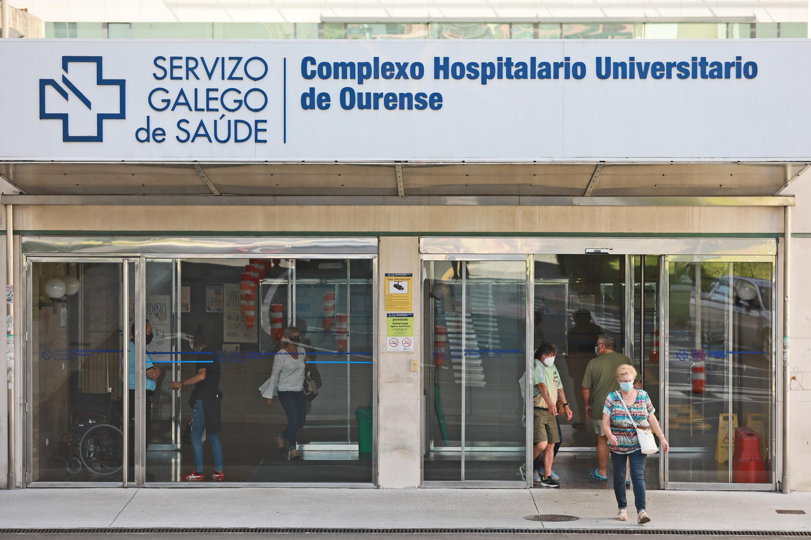 Varias personas cruzan la entrada del CHUO, en la mañana de ayer. (FOTO: José Paz)