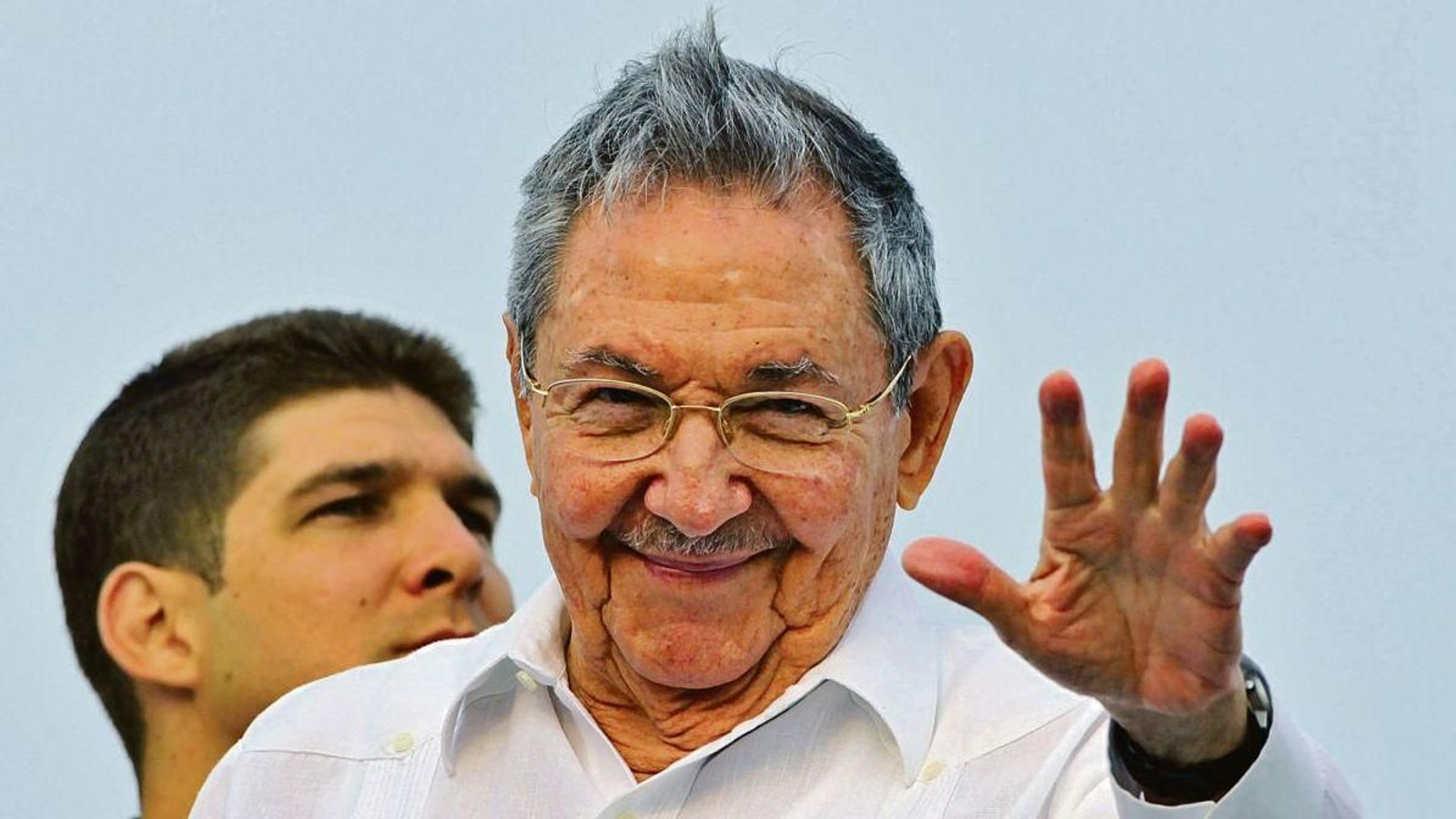 Raúl Guillermo Rodríguez detrás de su abuelo en un acto público en Cuba.
