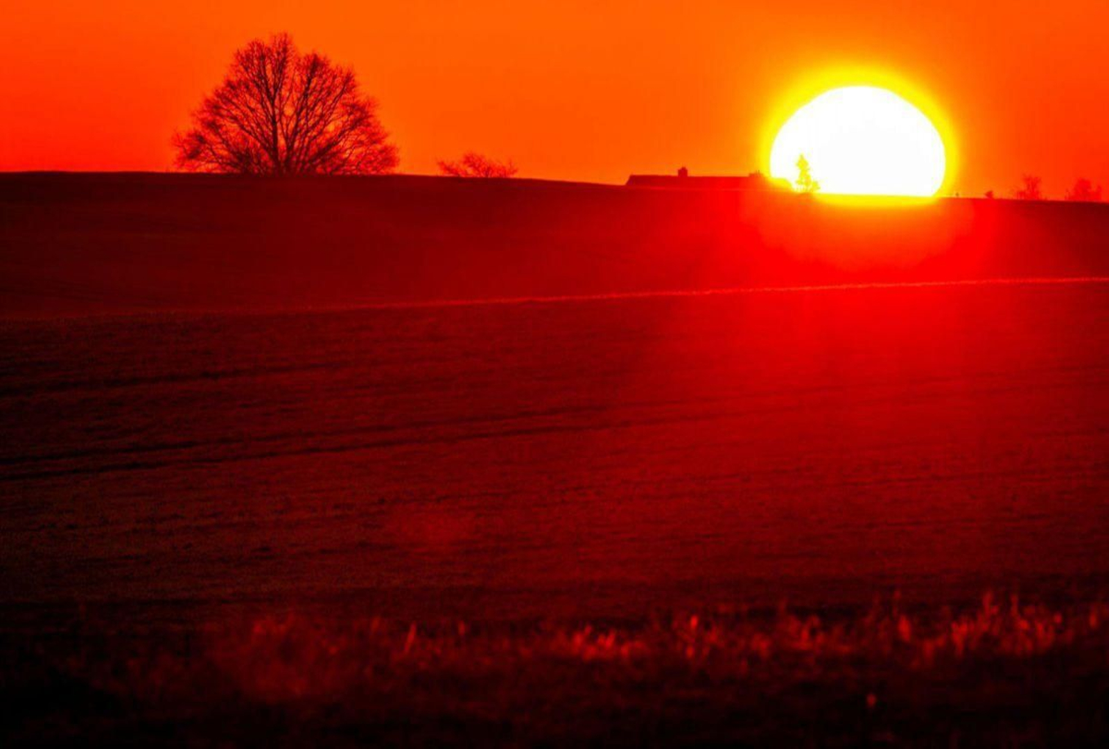 El Sol sale detrás de unas colinas en un día de invierno en el norte de Alemania.