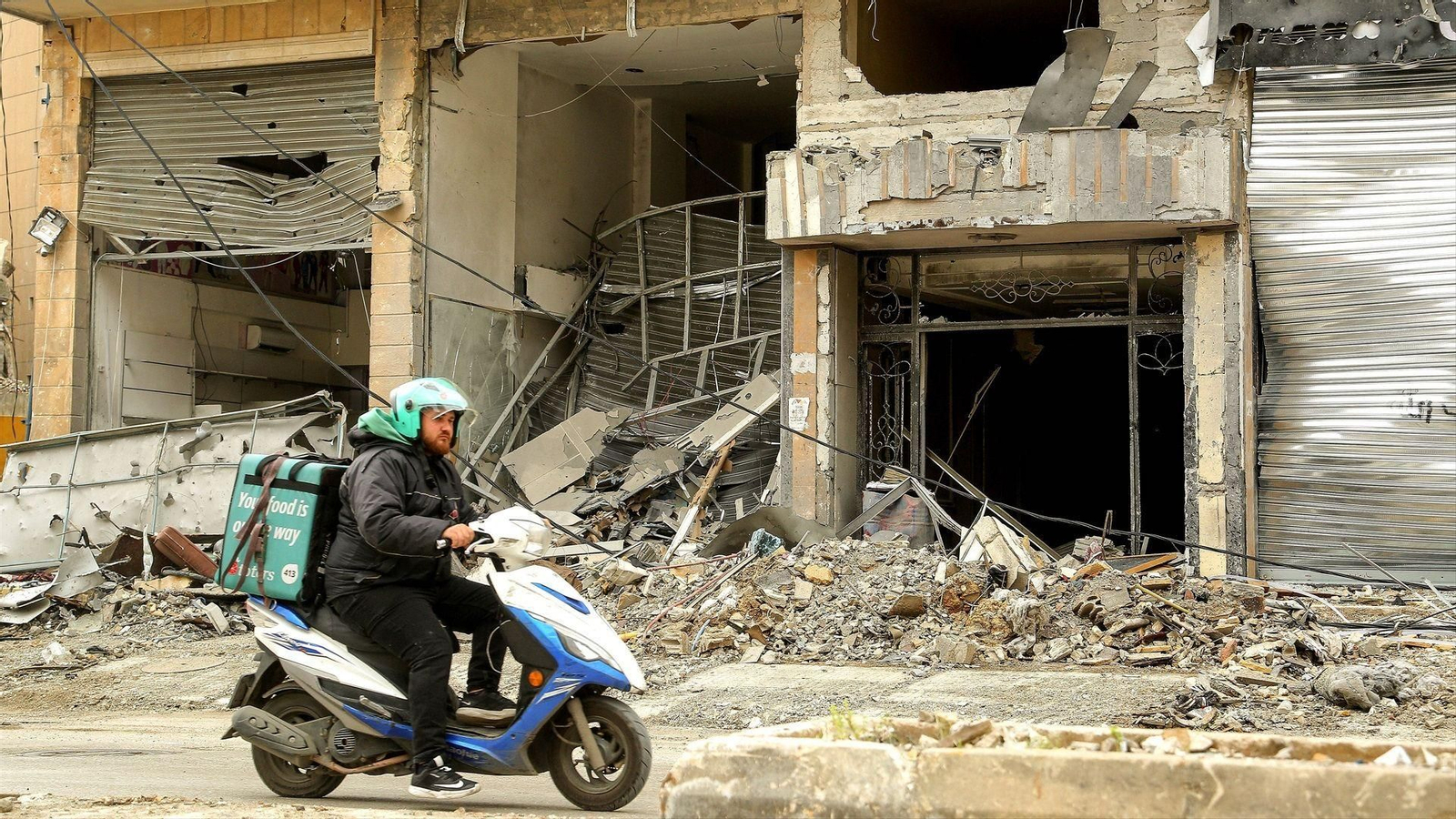 Un motorista circulando entre escombros en Beirut.