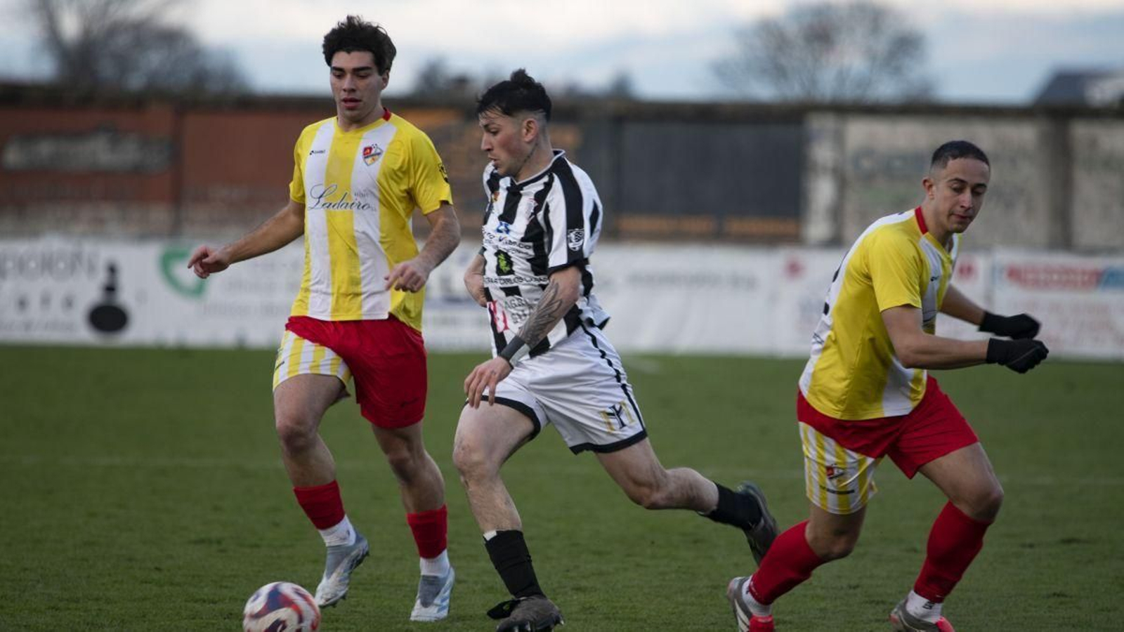 Tiago Teixeira, defensa del Antela, intenta superar a dos contrarios en A Moreira.