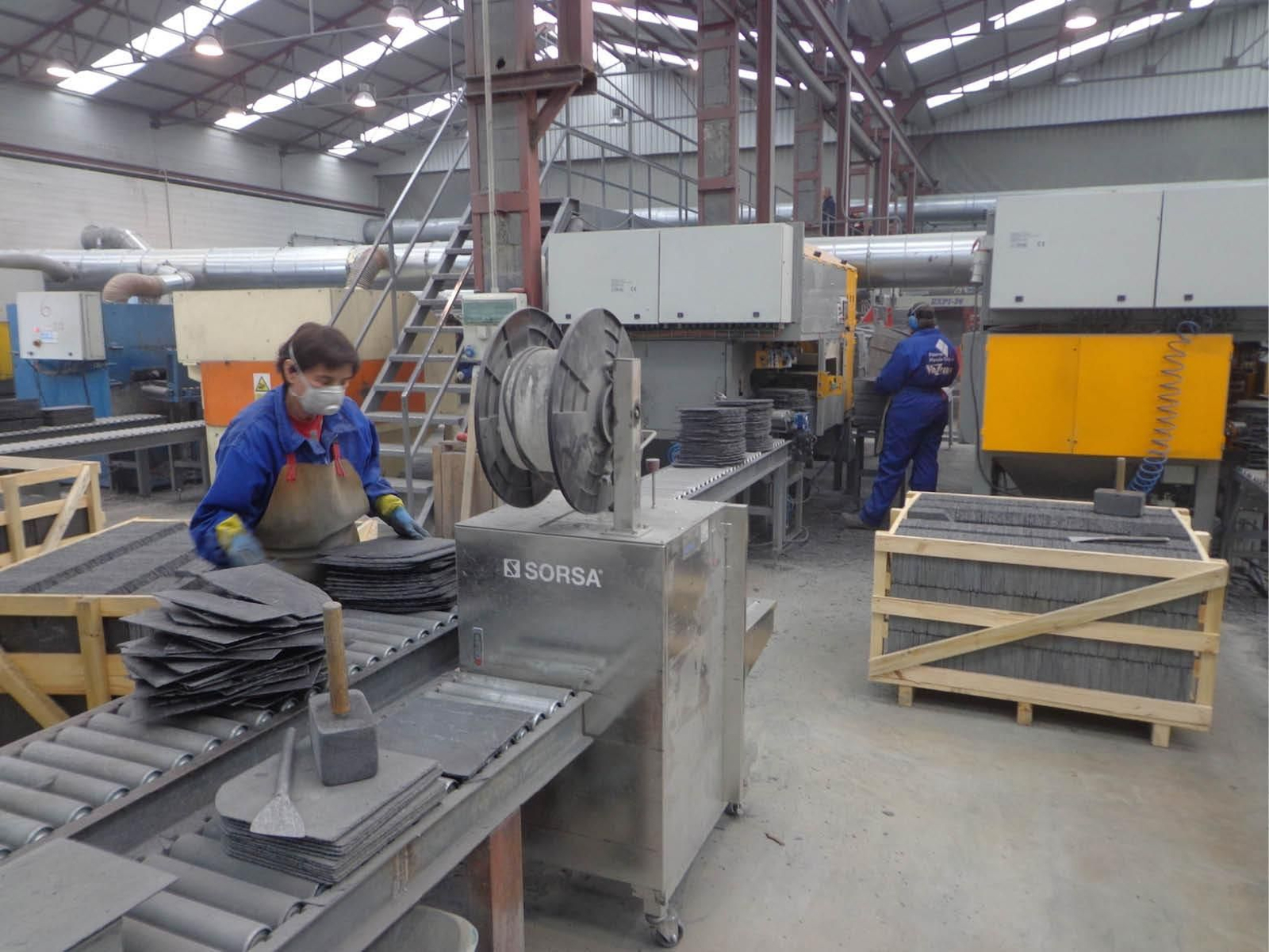 Trabajadores de una nave de producción de pizarra.