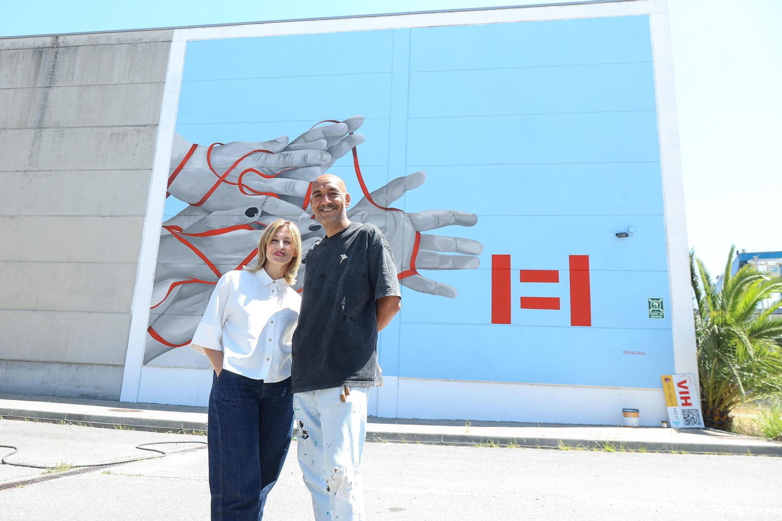 La responsable del proyecto y directora del Instituto Galicia Sur, con el artista Marcos Puhinger, ante el mural pintado en el IES Audiovisual de Bouzas.