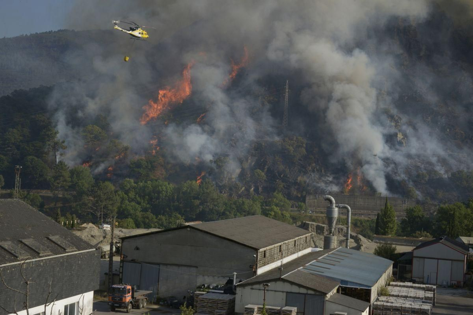 Un helicóptero trabaja en las tareas de extinción del incendio forestal de Ribas de Sil.