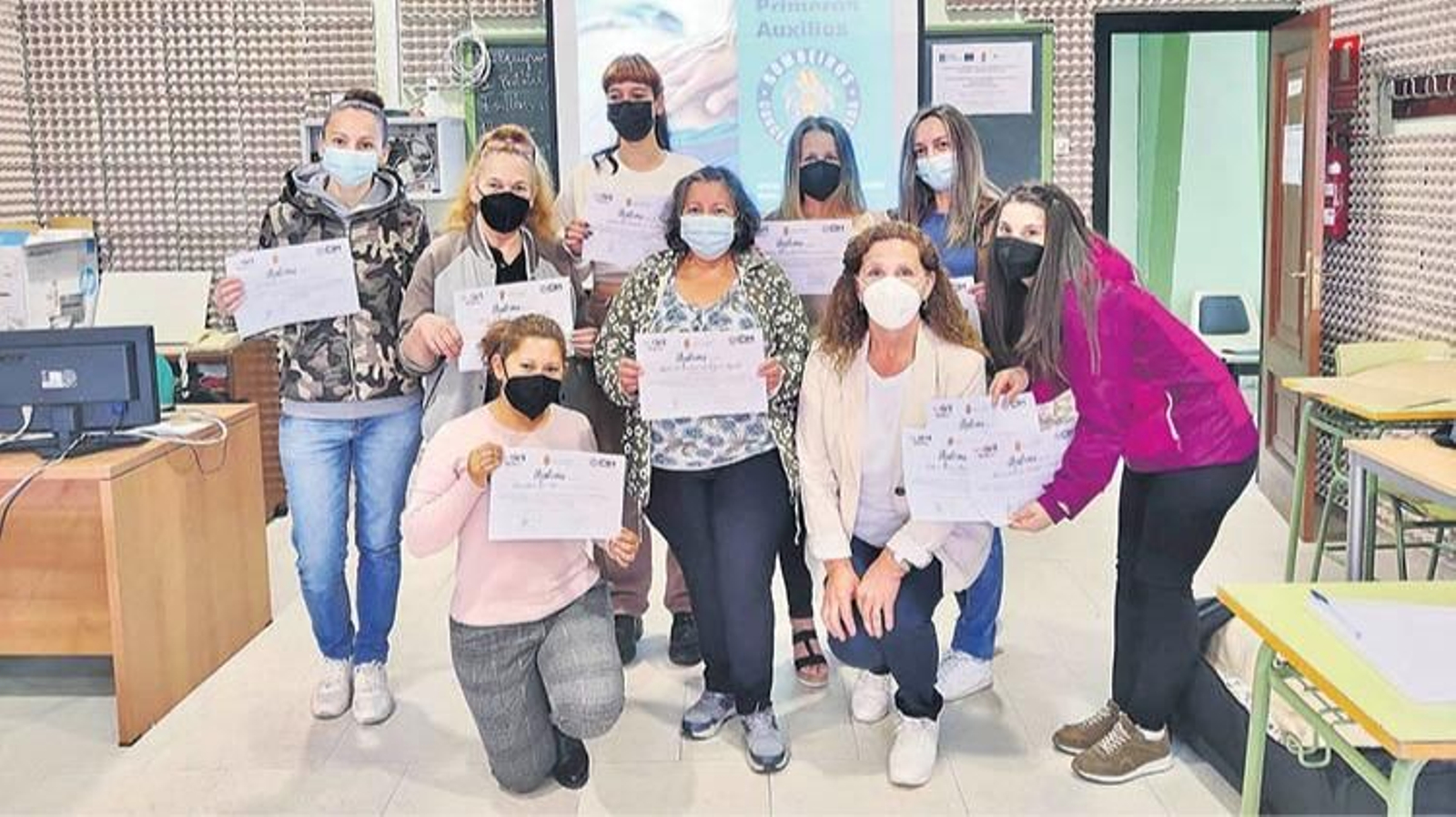 Un grupo de mulleres cos diplomas acreditativos.