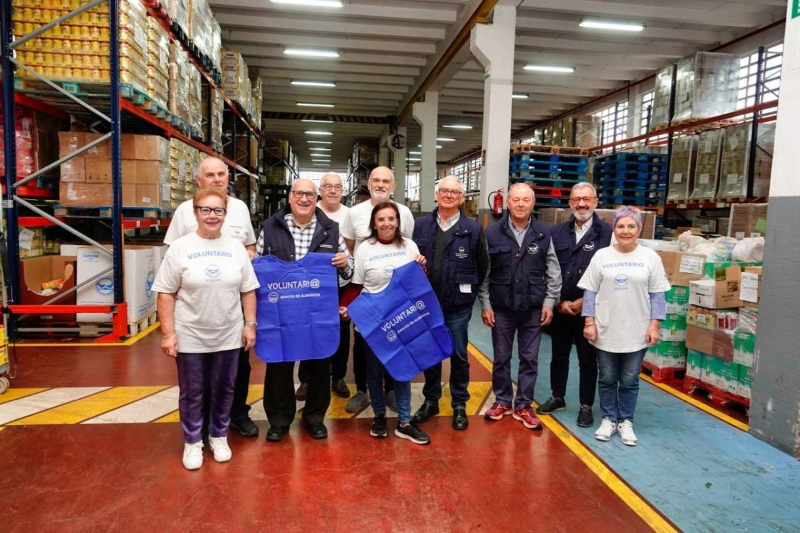 Presidente, vicepresidente y voluntarios posan en el almacén del Banco de Alimentos en Vigo.