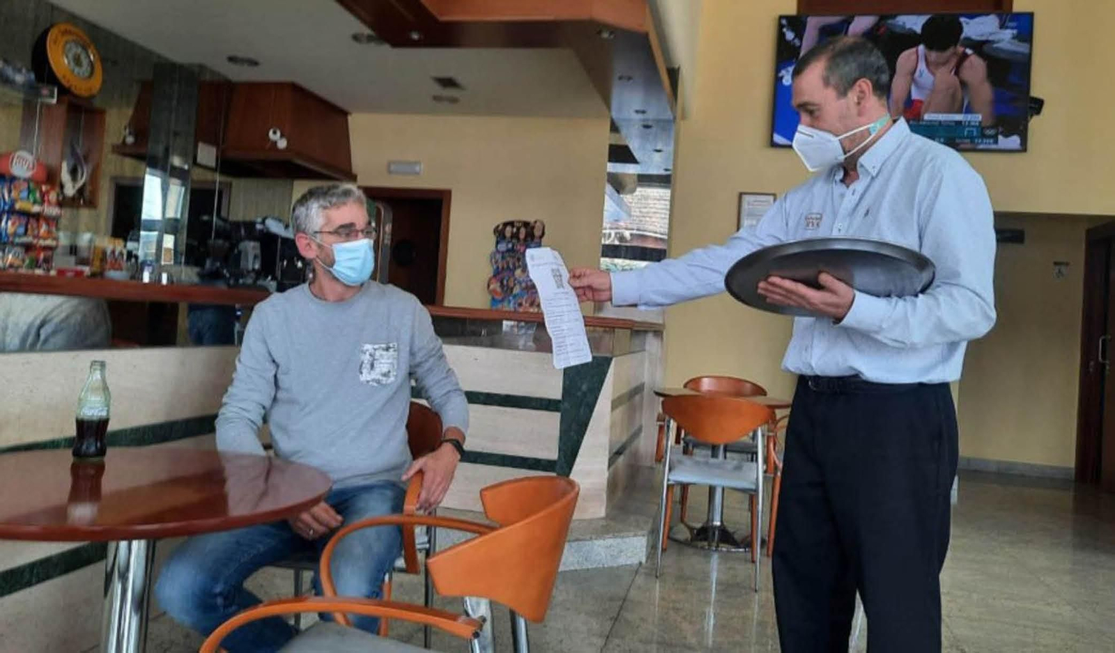 Un cliente enseña el pasaporte covid en un bar de Vigo.