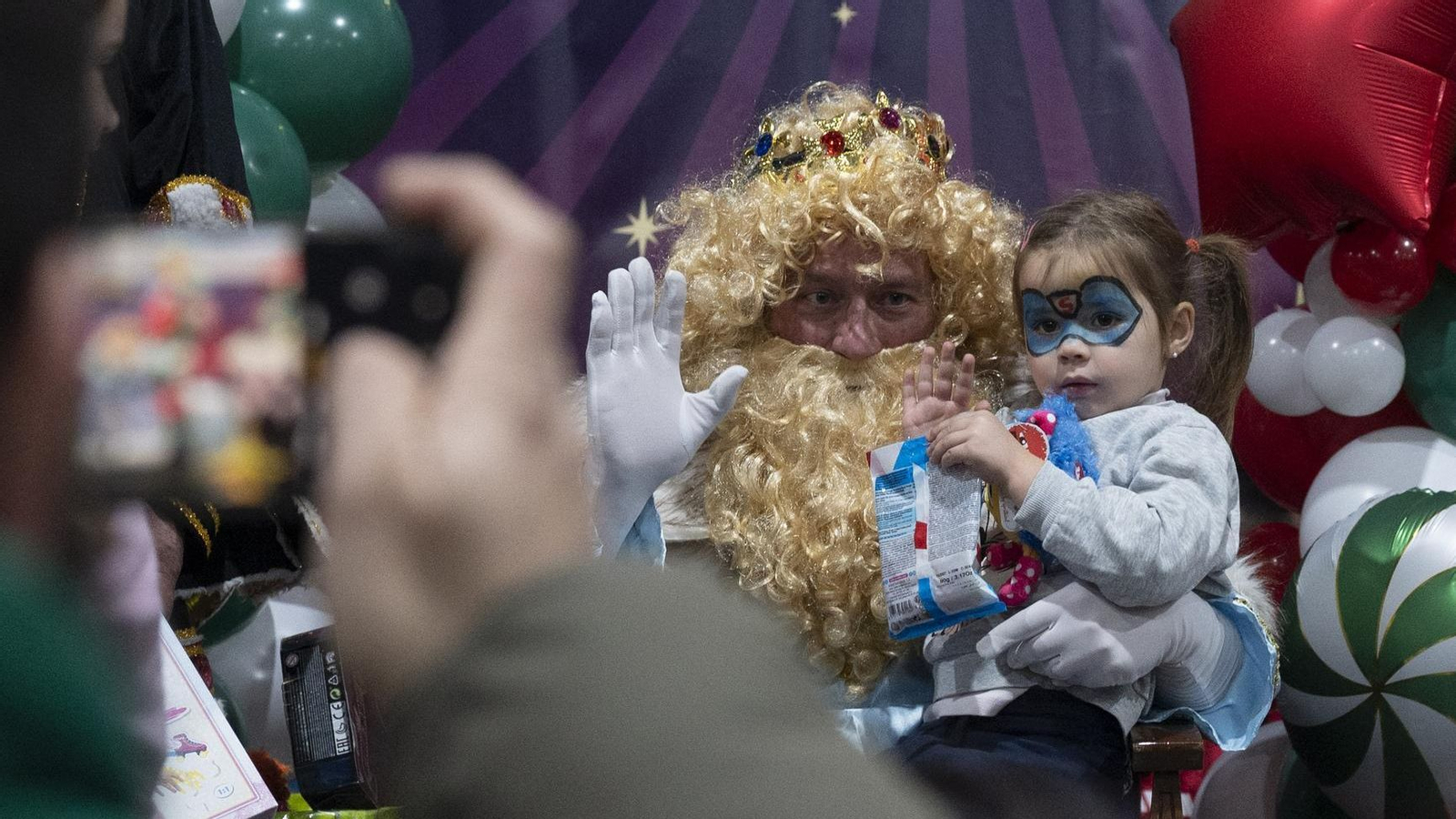 Melchor escucha las peticiones de una niña para los regalos de este año.