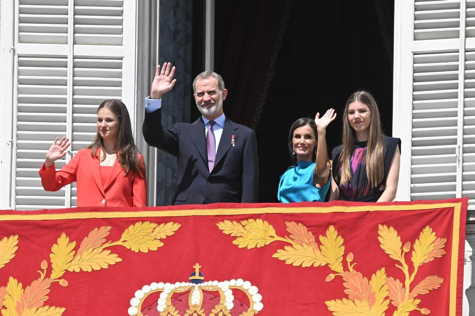 Los Reyes y sus hijas saludan desde el balcón del Palacio Real.