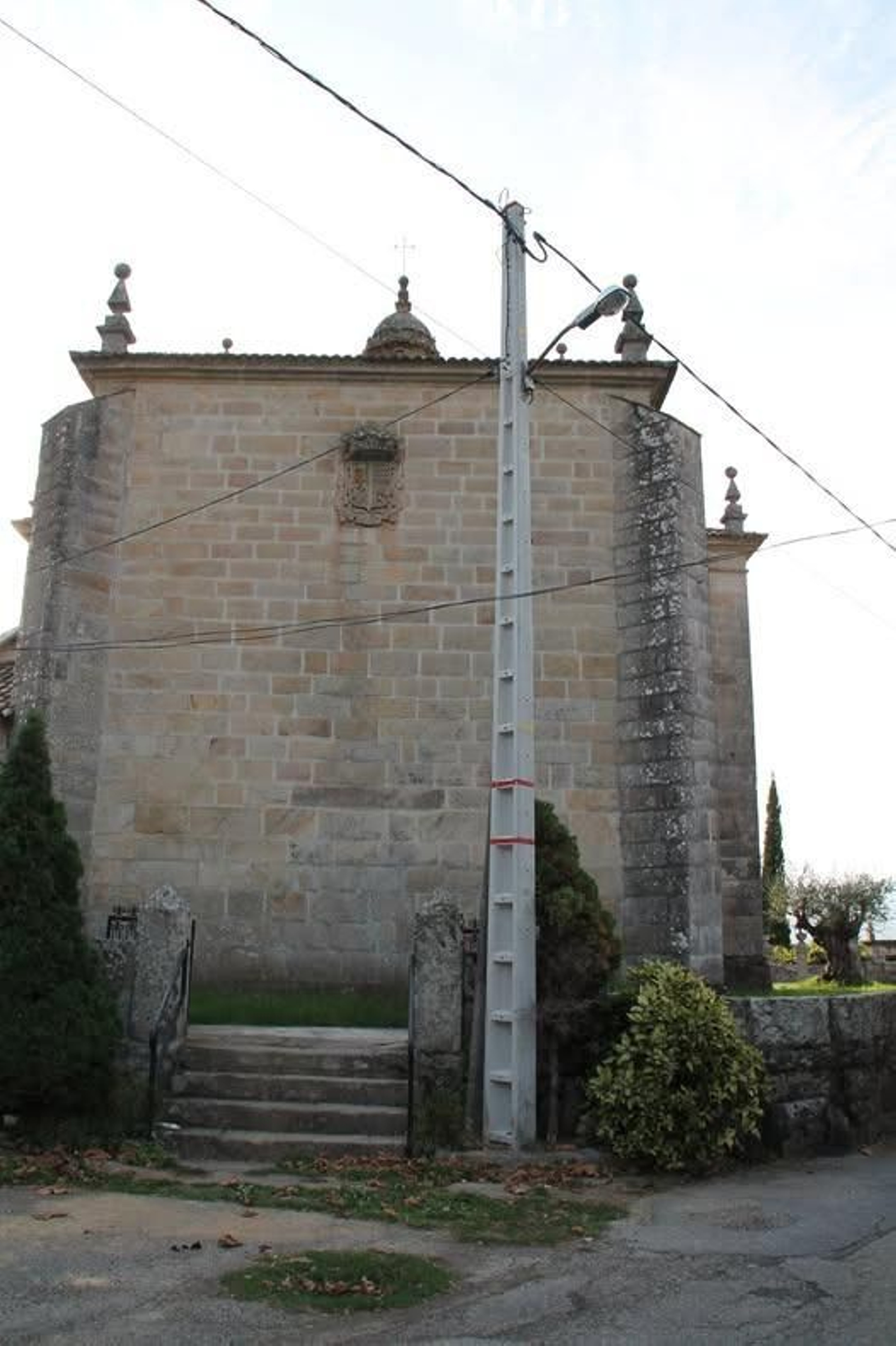 Uno de los postes junto a la fachada de la iglesia de Reboreda.