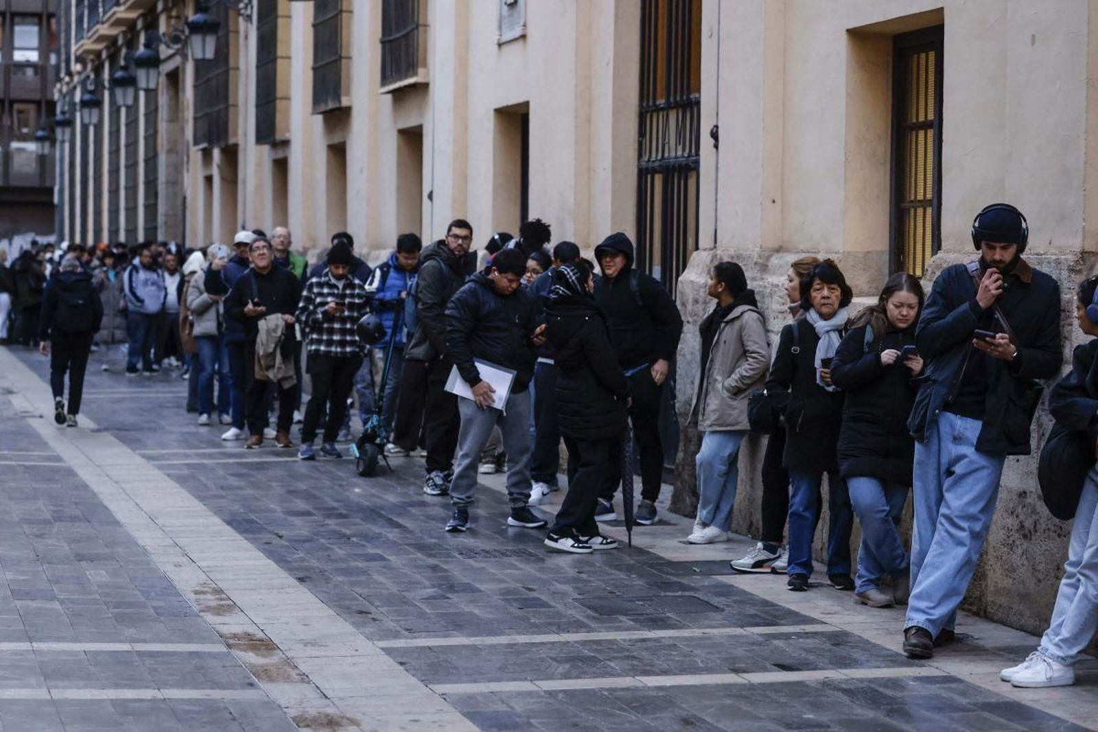 Decenas de inmigrantes hacen cola para una regularización extraordinaria en Valencia.