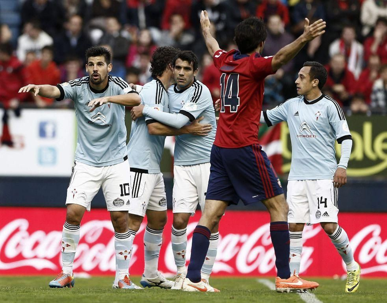 Fabián Orellana celebra con sus compañeros uno de los dos goles del Celta ayer en El Sadar.