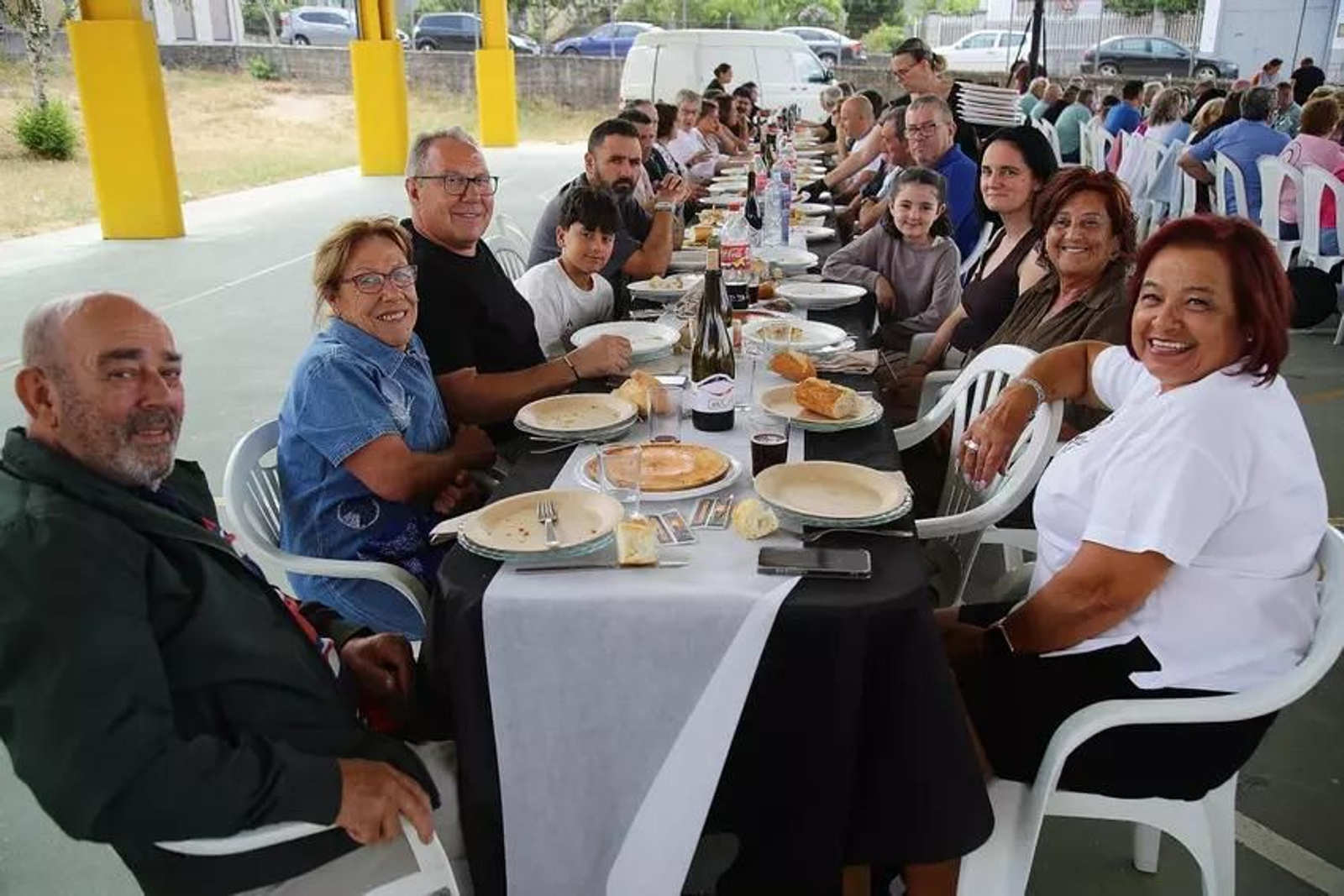 Unha familia reunida a carón dunha mesa na Festa da Bica, Trives