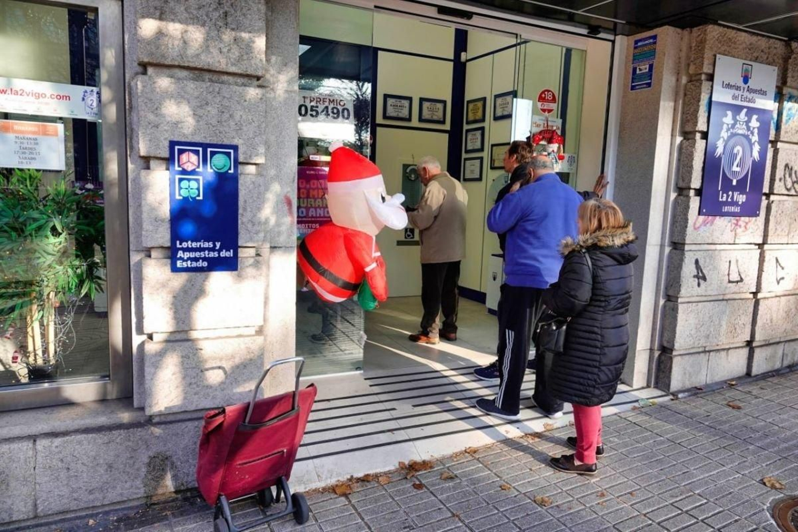 Clientes de la administración hacen cola para comprar los últimos boletos de la lotería de Navidad.