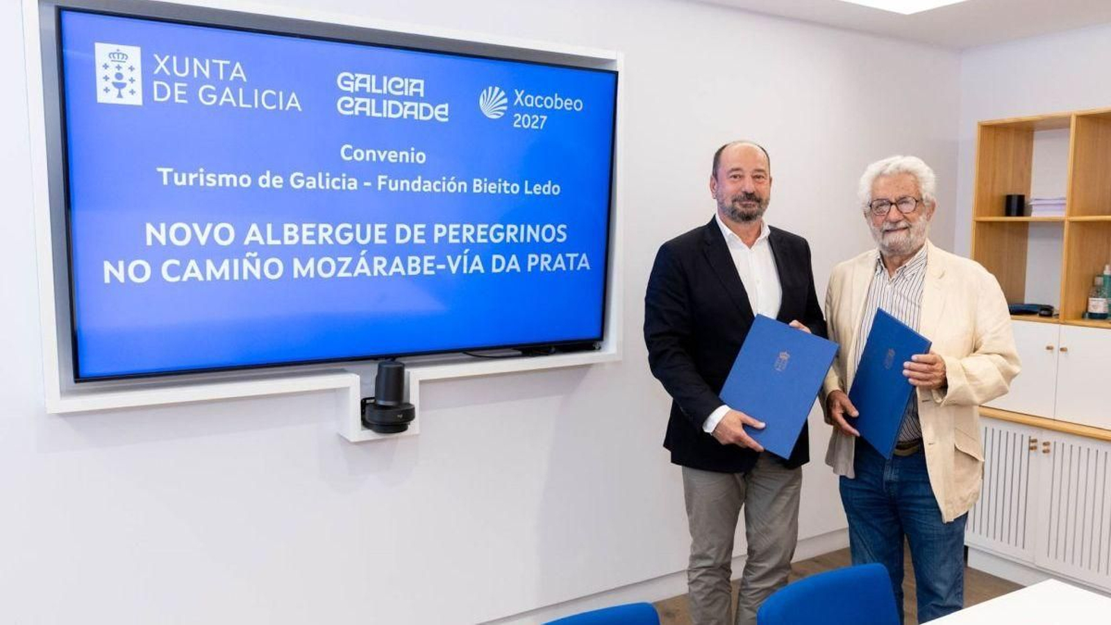 Xosé Merelles y Bieito Ledo con el documento de colaboración recién firmado en la mano.