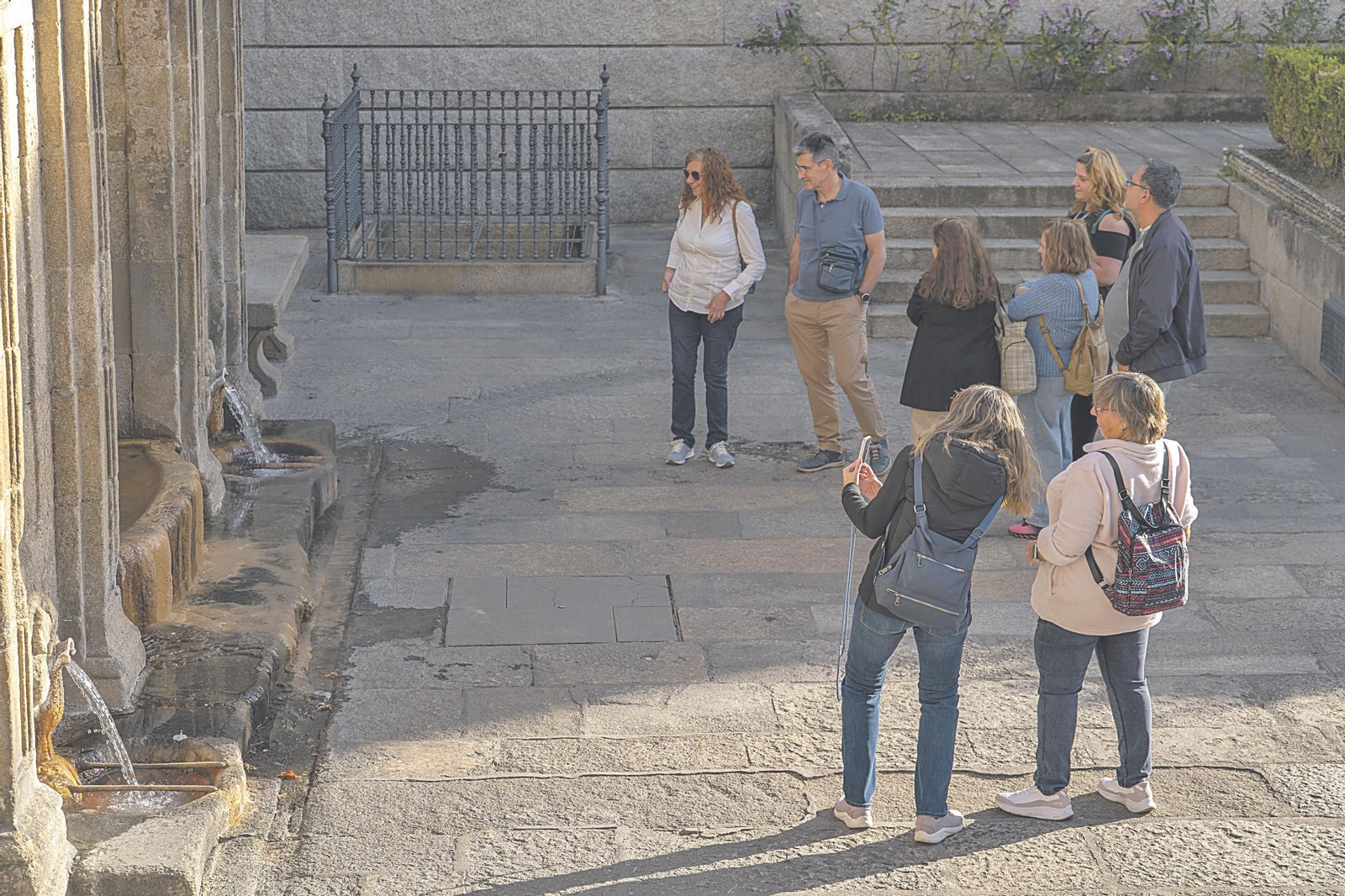 Un grupo de turistas contempla la fuente de As Burgas ayer por la tarde, en un tour por la ciudad.