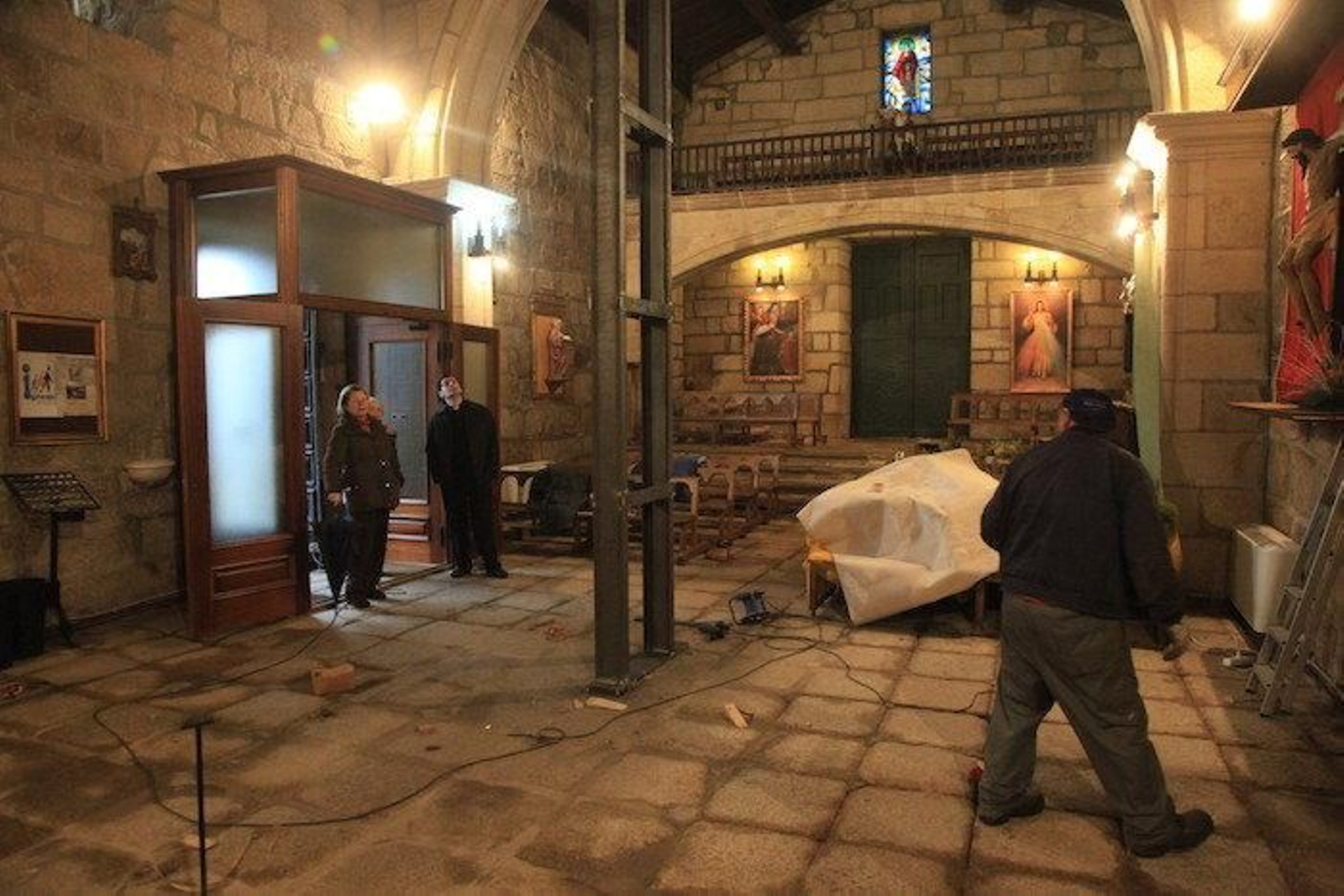 Personas dentro de la iglesias intentando limpiar el suelo.