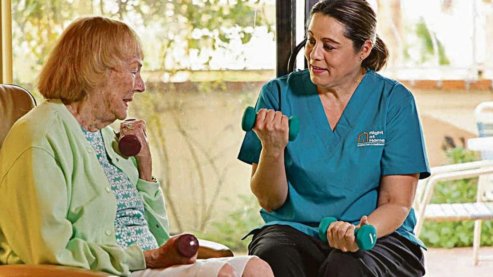 Una paciente realiza ejercicios junto a una cuidadora.