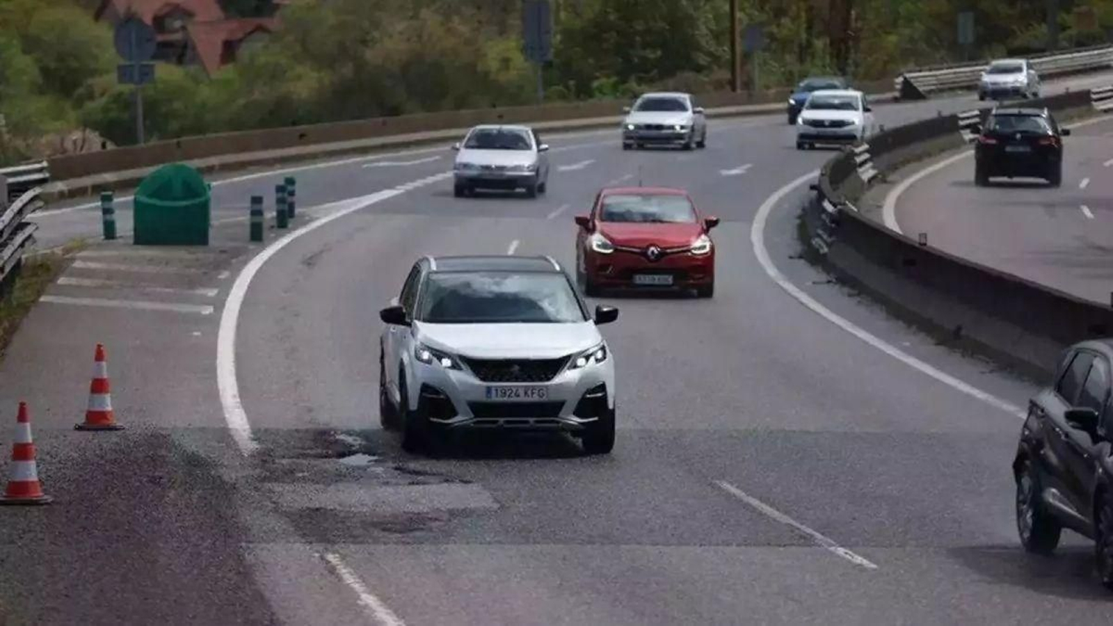 Vehículos circulando por la A-55 junto a un bache.