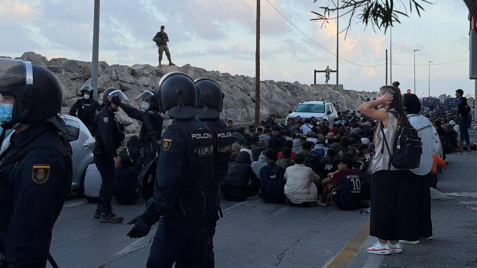 Los Cuerpos de Seguridad del Estado organizan a los migrantes para su traslado al Puerto de Ceuta.