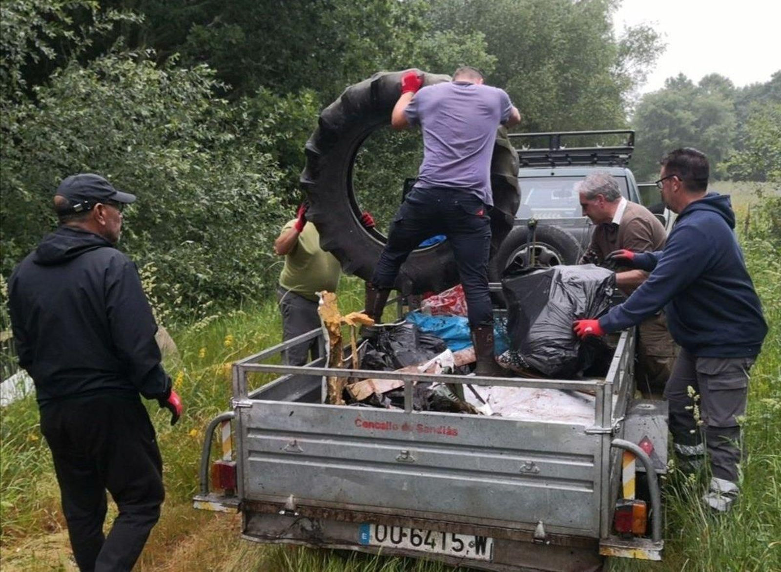 Participantes axudando na recollida dunha roda de tractor.