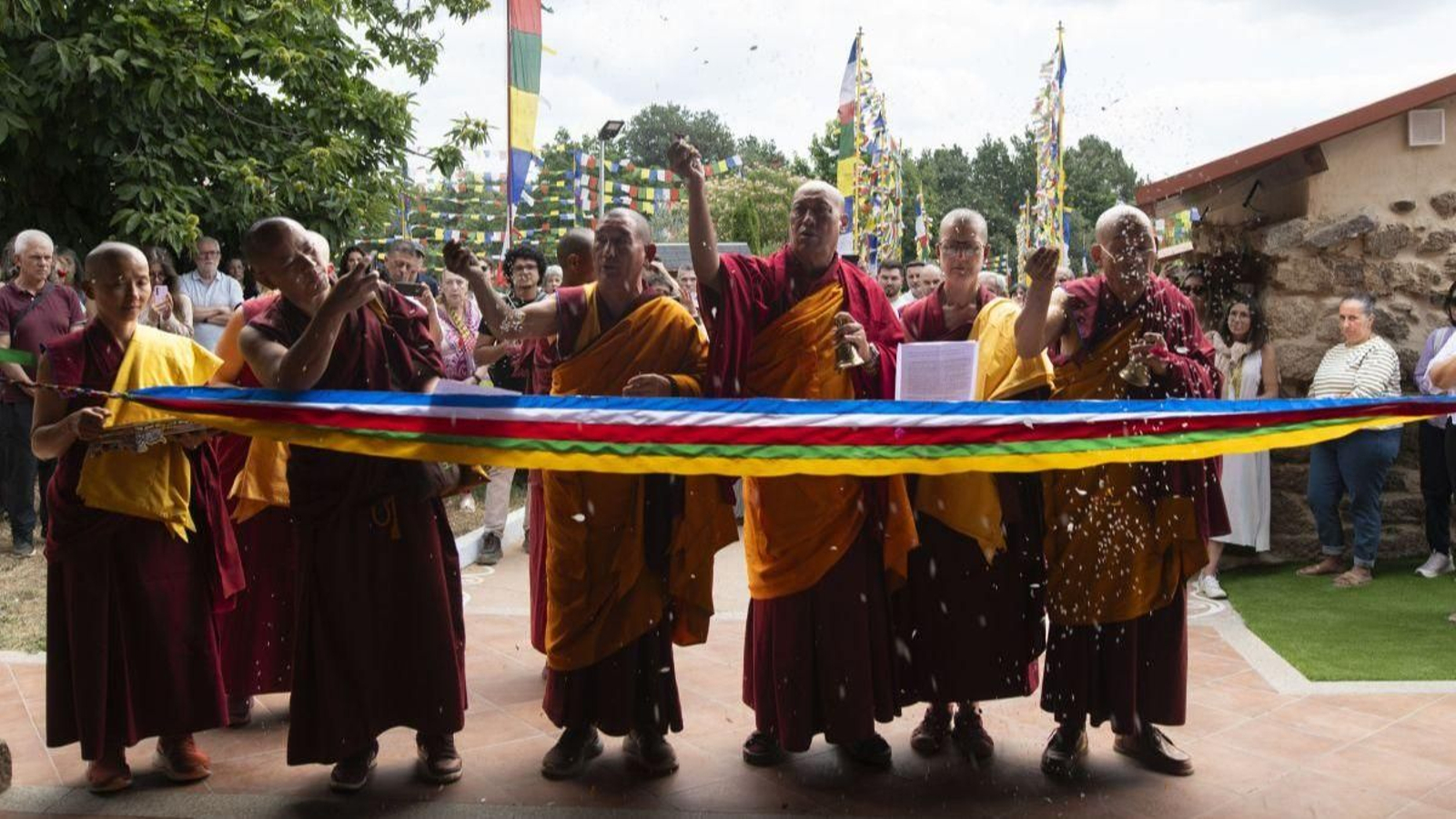 El lama Gueshe Tenzing Tamding, acompañado por autoridades religiosas y monjes, durante el corte de la cinta de reapertura.