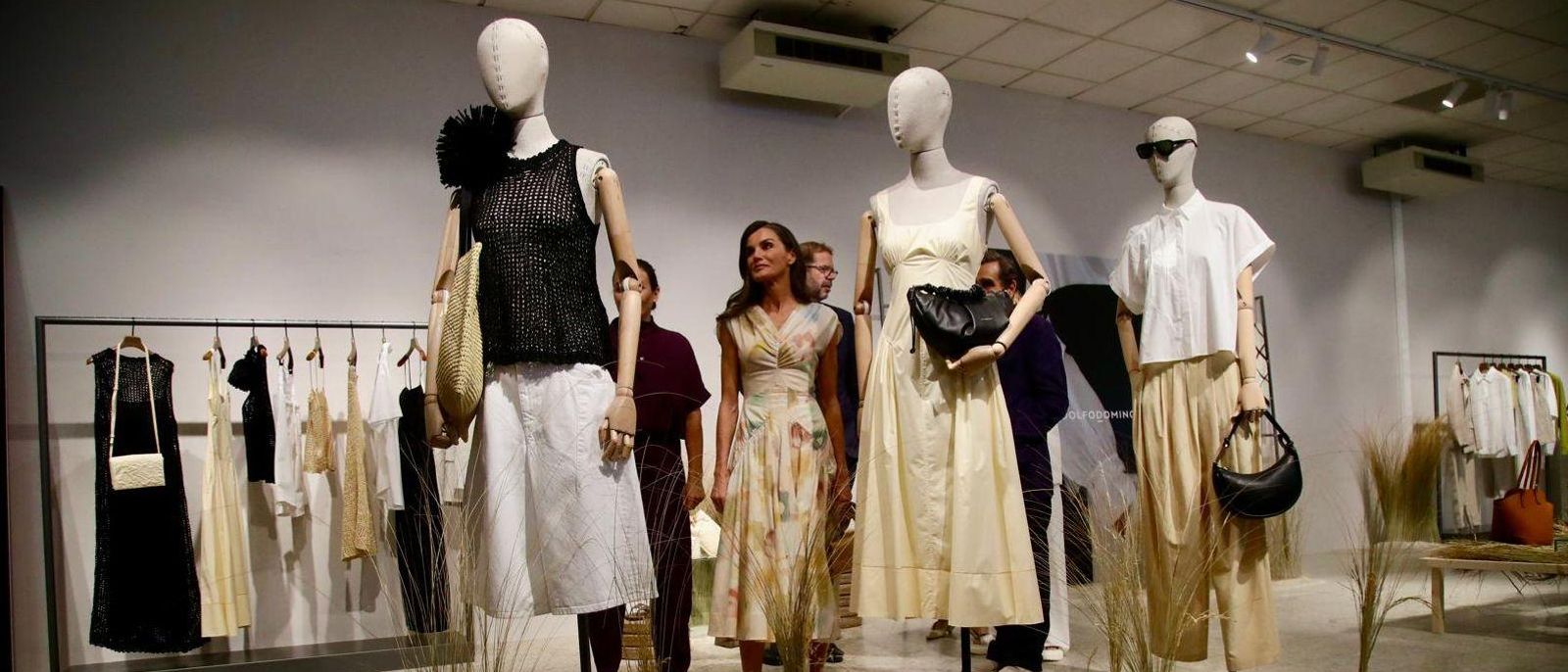 La reina Leticia durante su visita a la sede de Adolfo Domínguez contempla algunos de los diseños de la marca.
