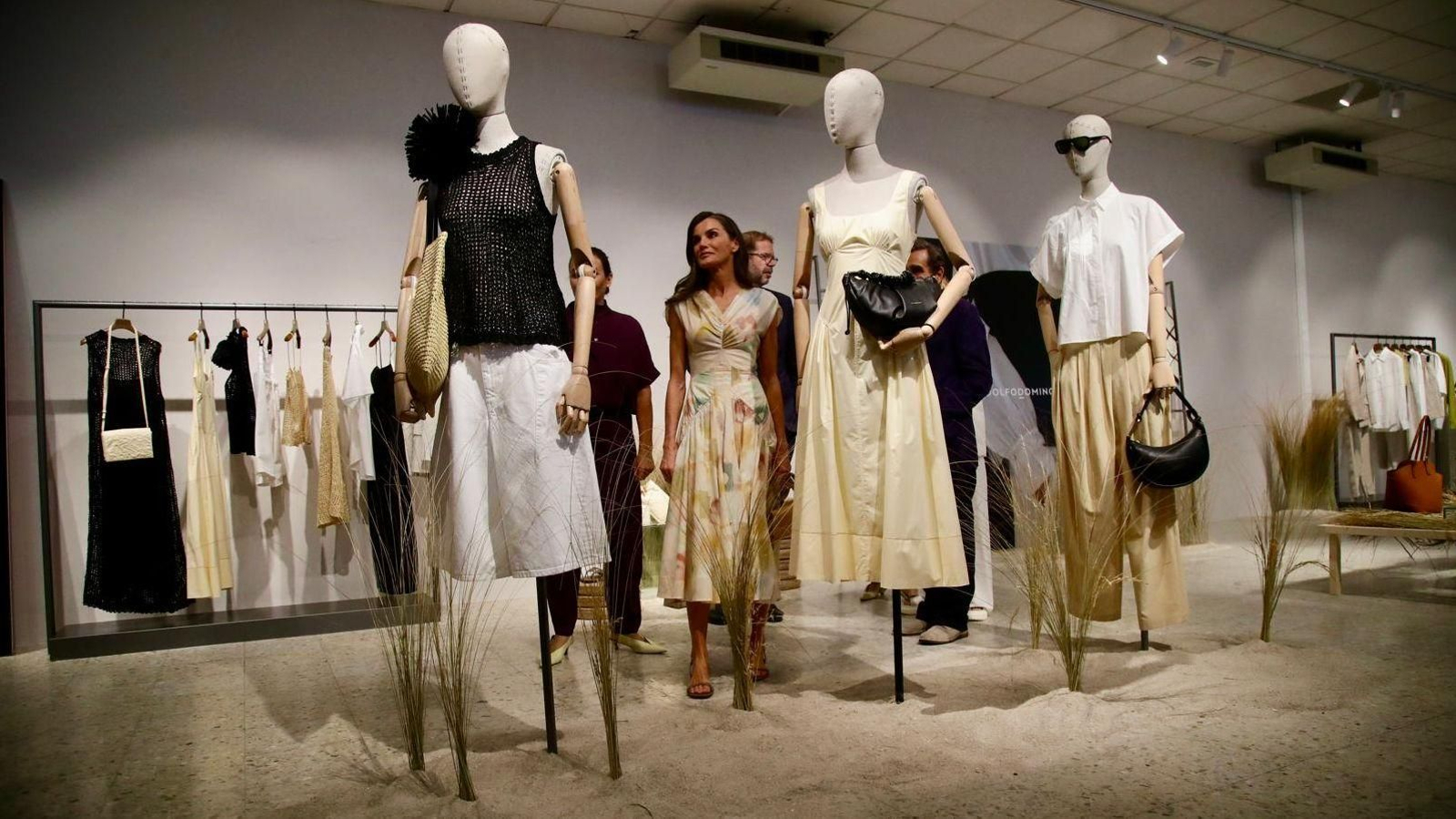 La reina Leticia durante su visita a la sede de Adolfo Domínguez contempla algunos de los diseños de la marca.