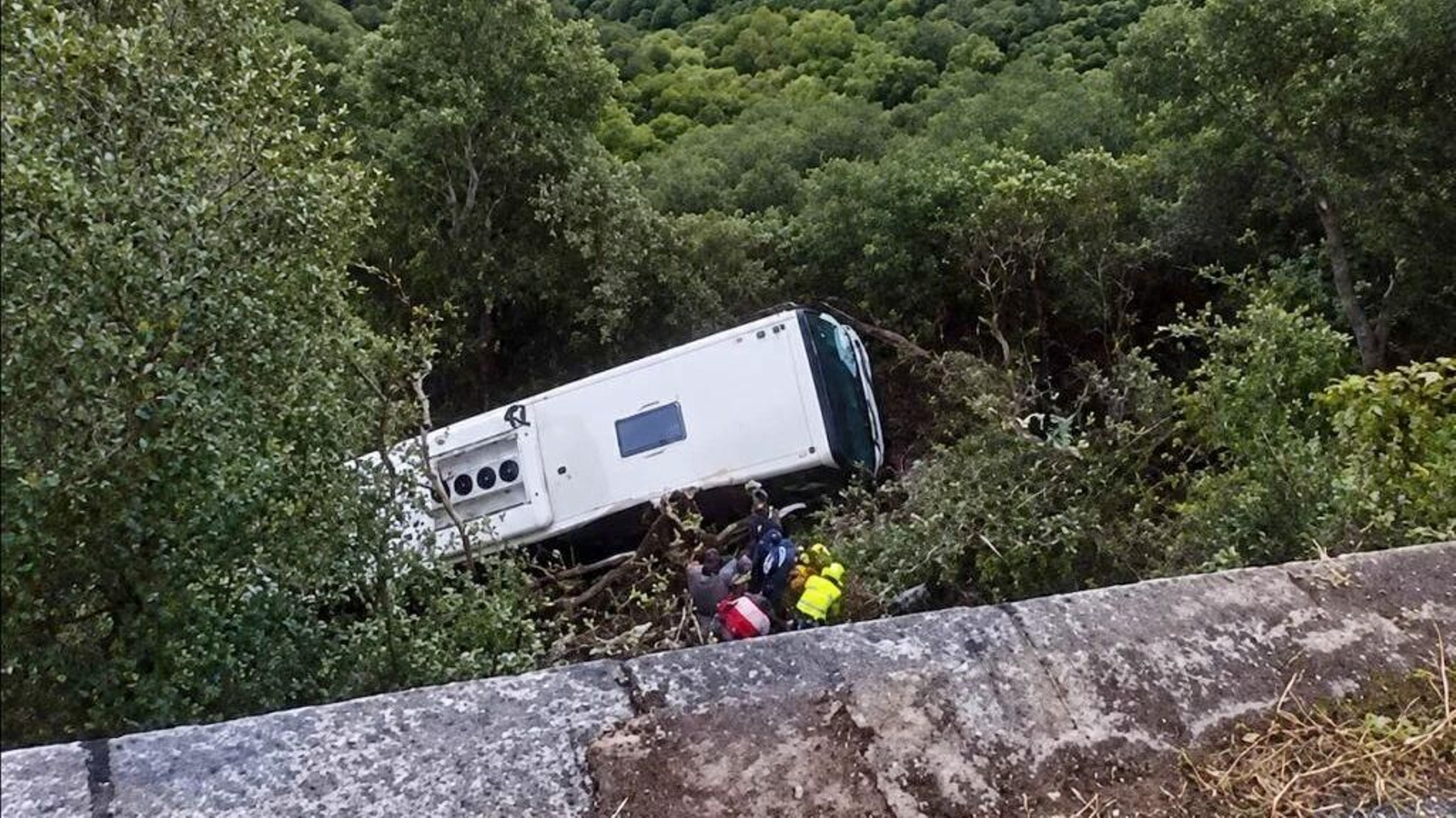 El autobús accidentado en Barcelona y los equipos de emergencia trabajan en el rescate de los heridos.