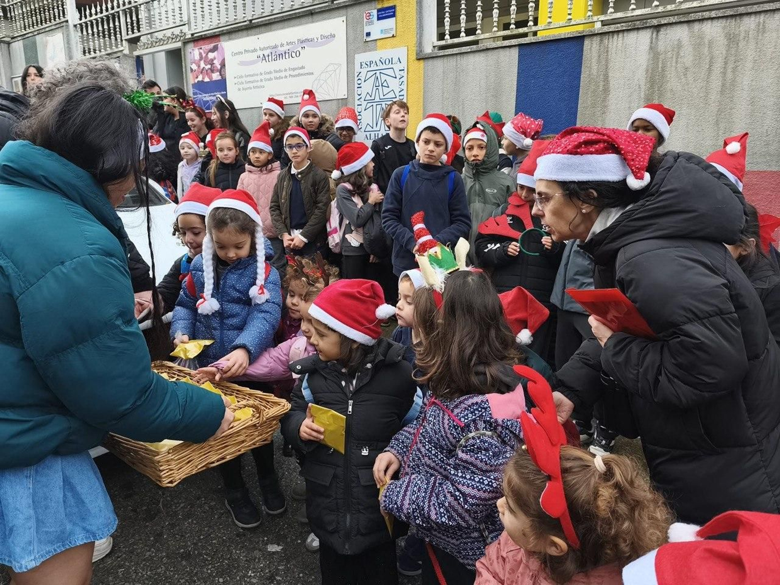 Los alumnos, recogiendo su aguinaldo tras cantar en uno de los negocios de la zona.