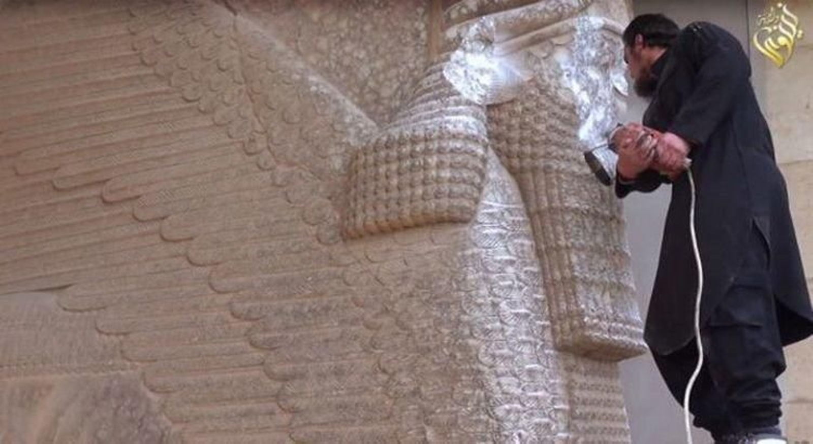 Un miembro del EI tratando de destruir una estatua en Mosul.
