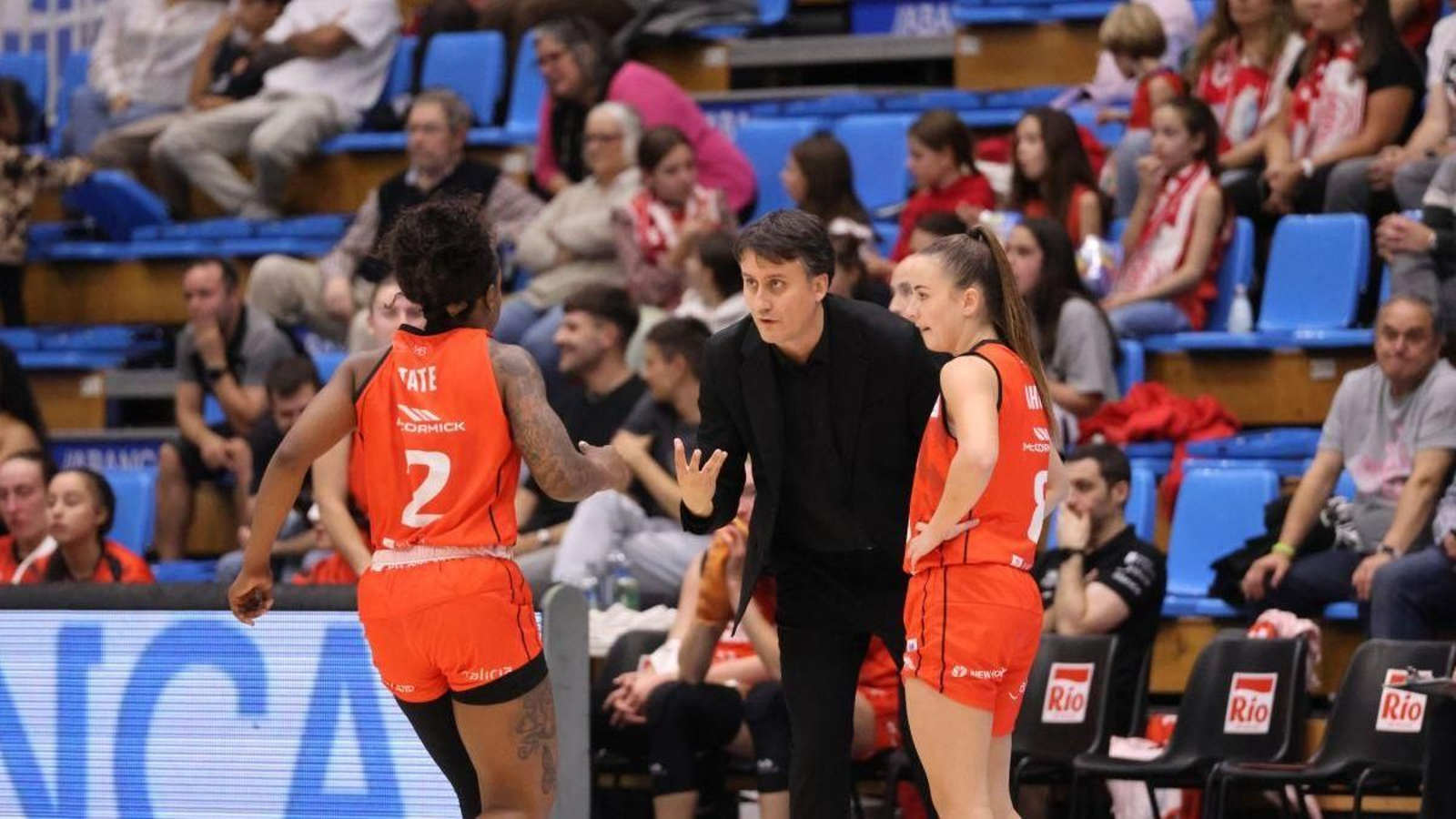 Suso Garrido habla con sus jugadoras Tate y Bosch durante un encuentro del Ensino.