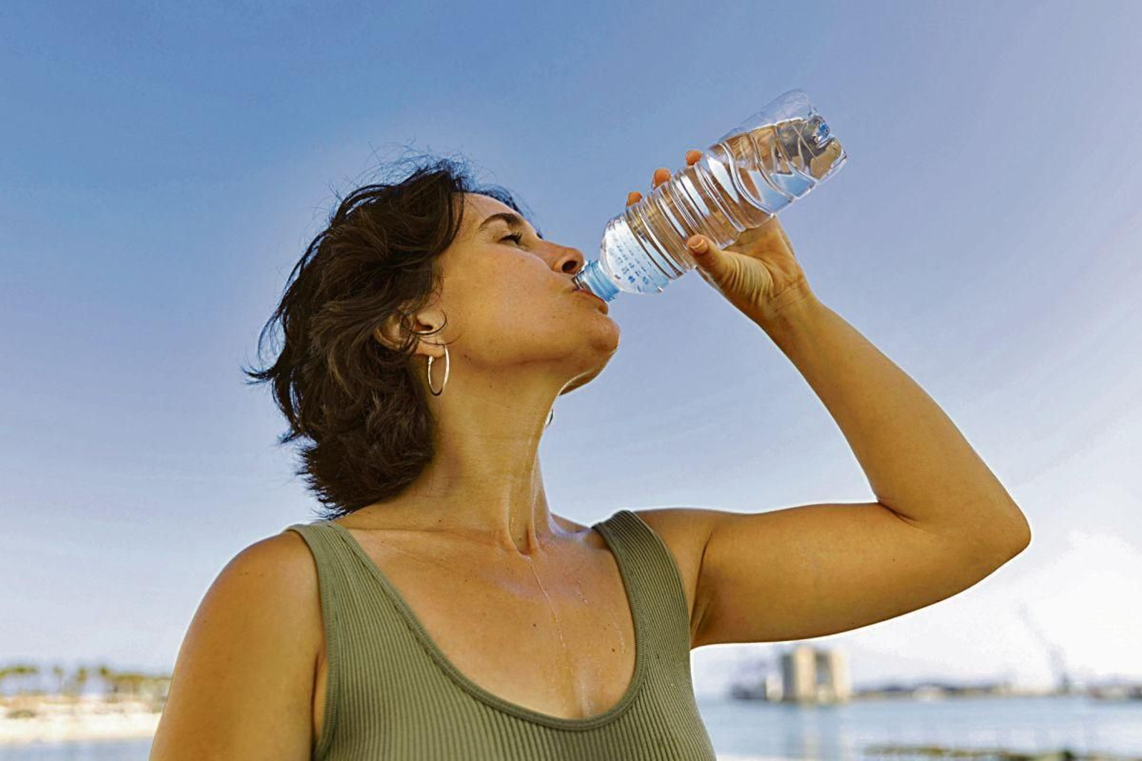 Una mujer bebe agua.
