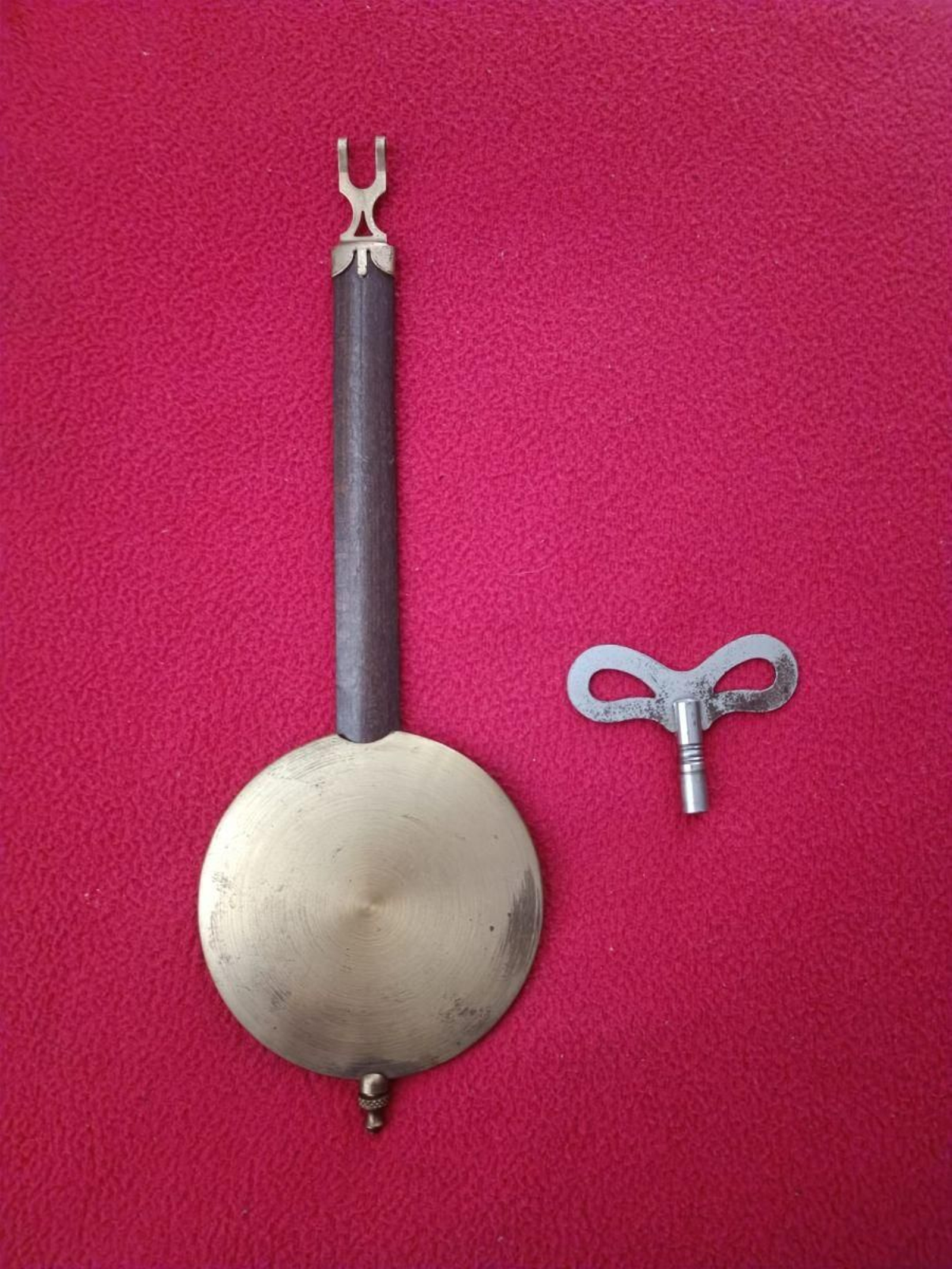Hermoso péndulo y llave para dar cuerda al reloj.