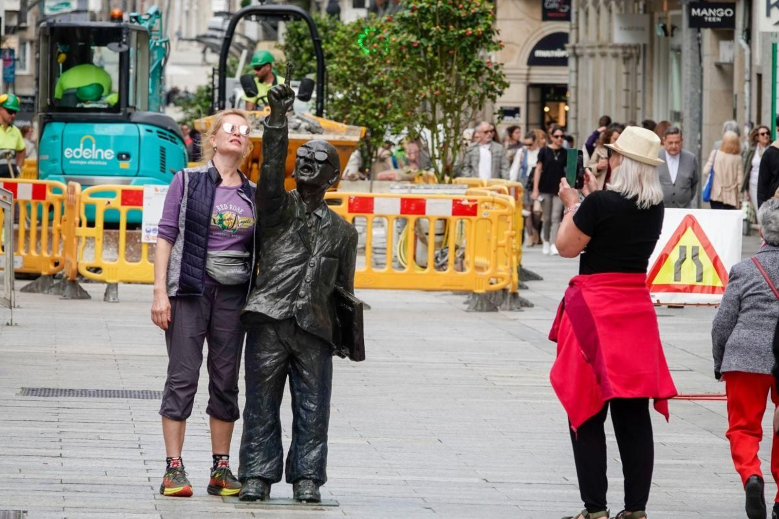 Turistas en Vigo paseando por la calle Príncipe y haciéndose fotos con la figura de Manuel de Castro