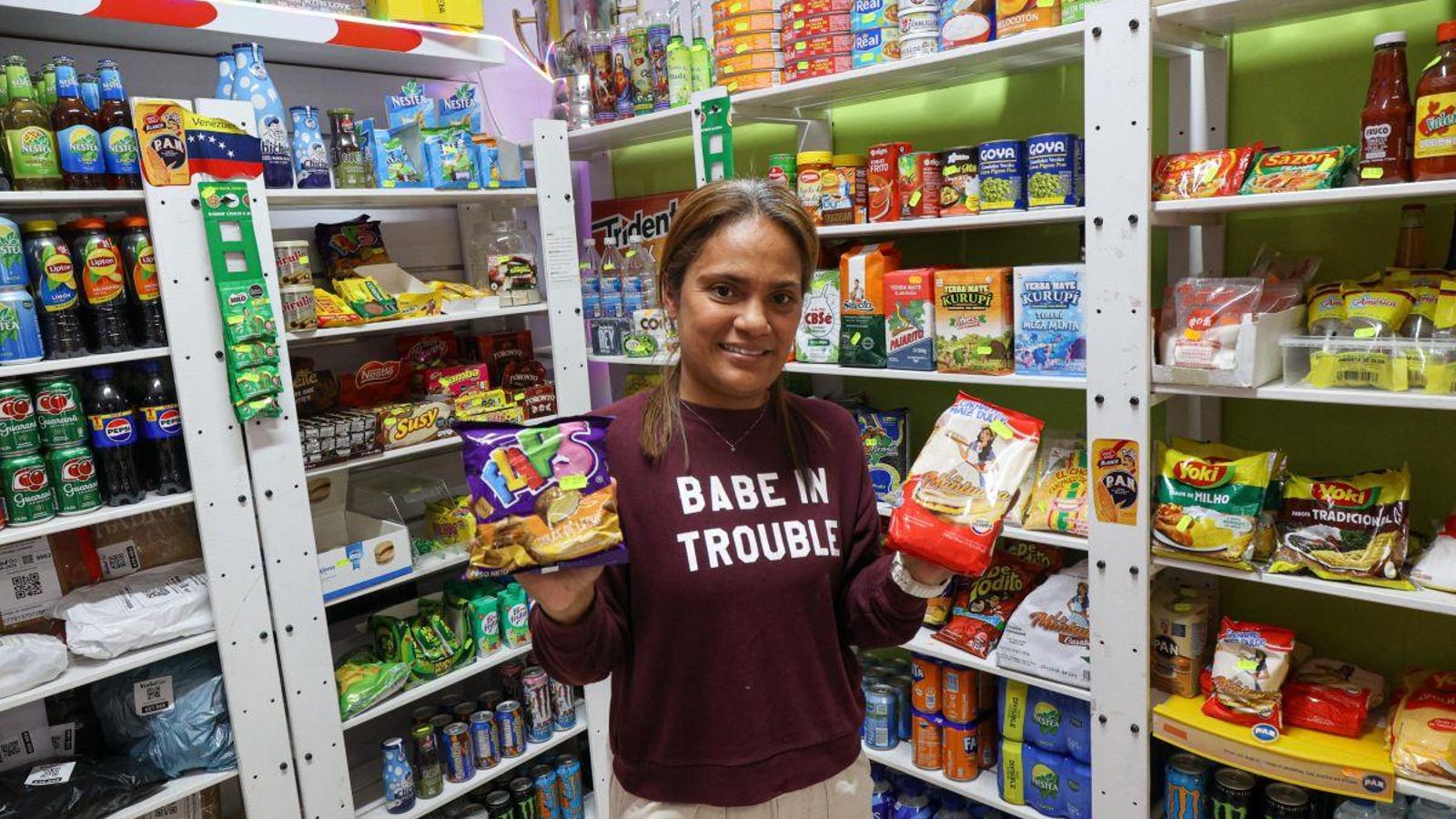Una empleada de “Dulzia”, con dos productos de importación.