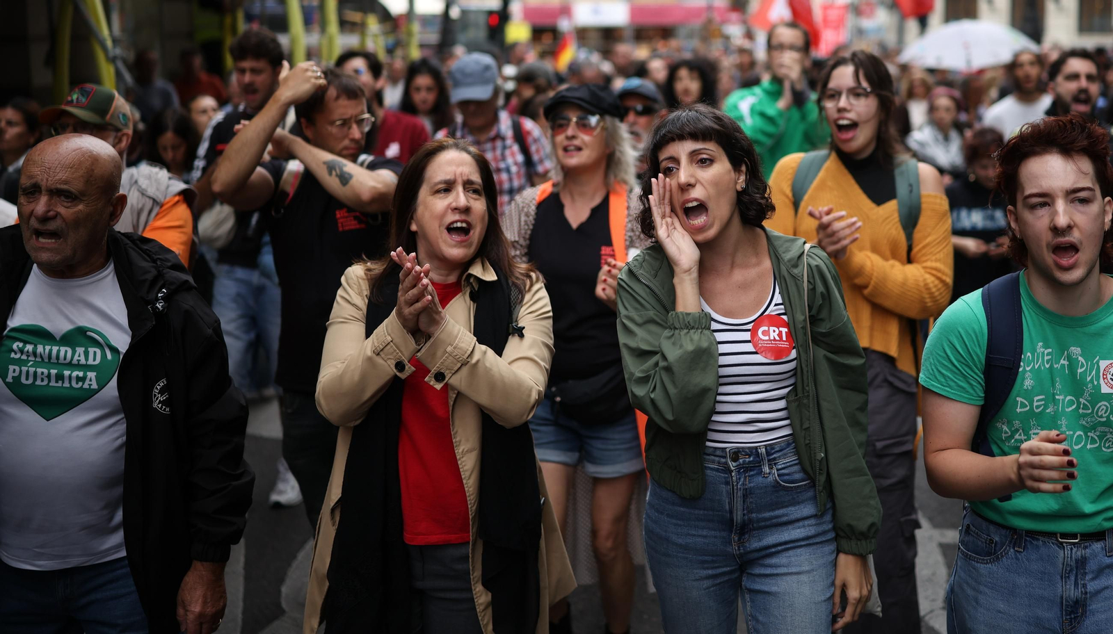 Manifestantes concentrados ante el cordón policial desplegado en los aledaños del Congreso de los Diputados durante la protesta en defensa del derecho a la vivienda