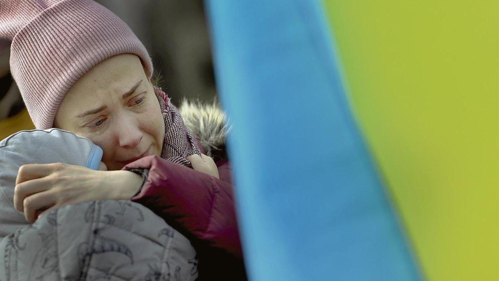 Una mujer ucraniana, con su hijo en brazos, llora durante la concentración de respaldo a su pueblo que tuvo lugar en Oviedo, convocada por la asociación “Ucranianos en Asturias”.