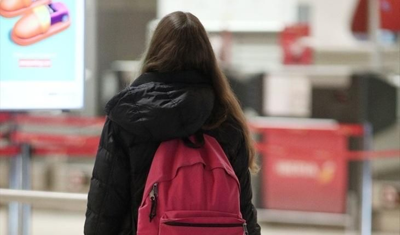 Una joven con una mochila camino de aeropuerto