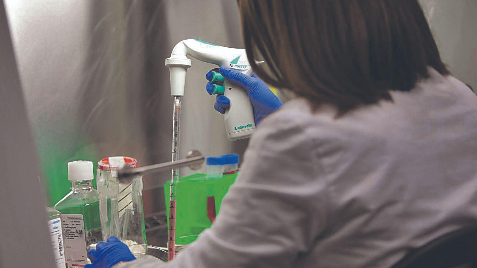 Una investigadora tomando muestras en un laboratorio.