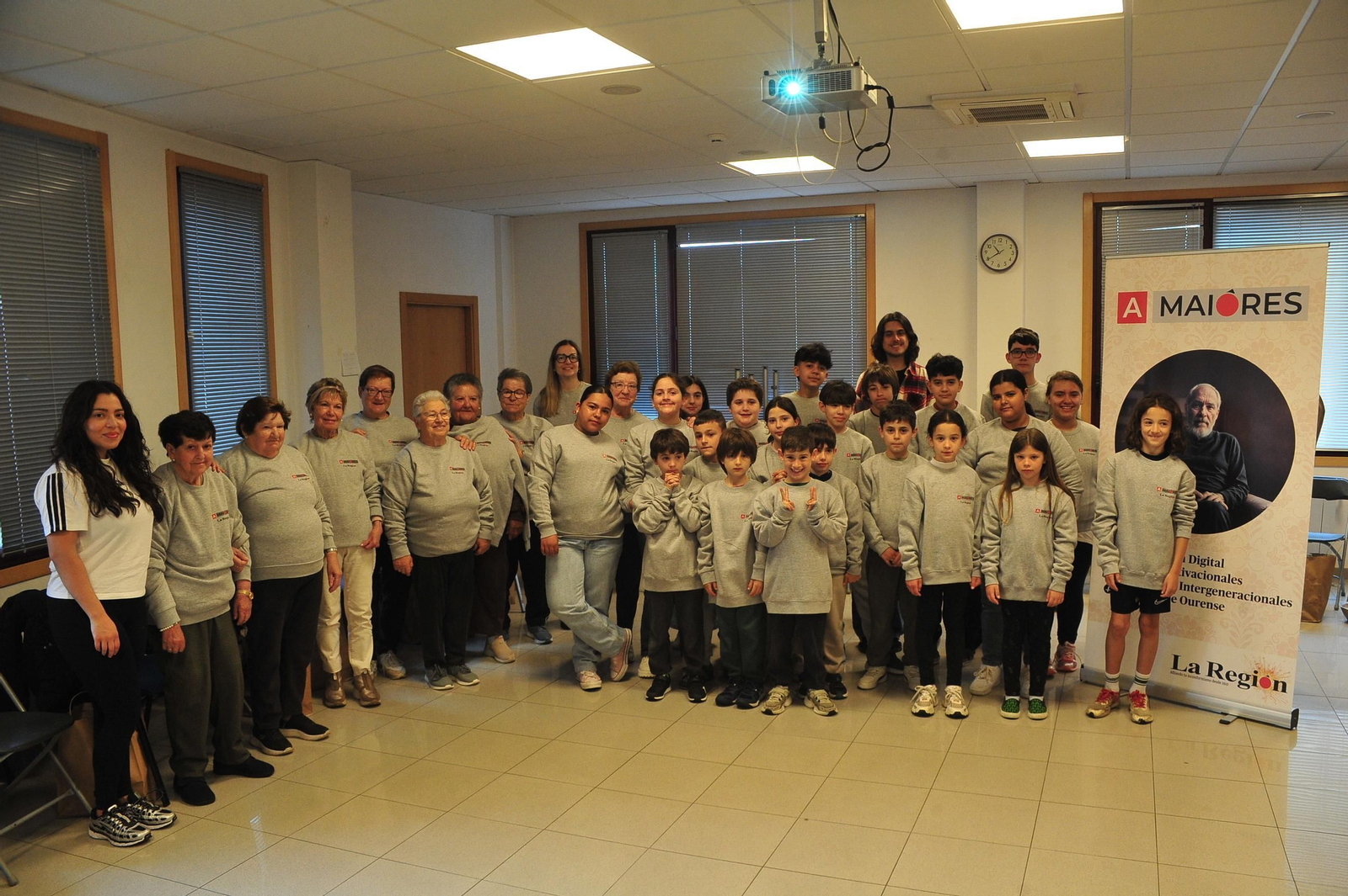 Los mayores y niños asistentes a la actividad, vestidos con la sudadera gris del programa.