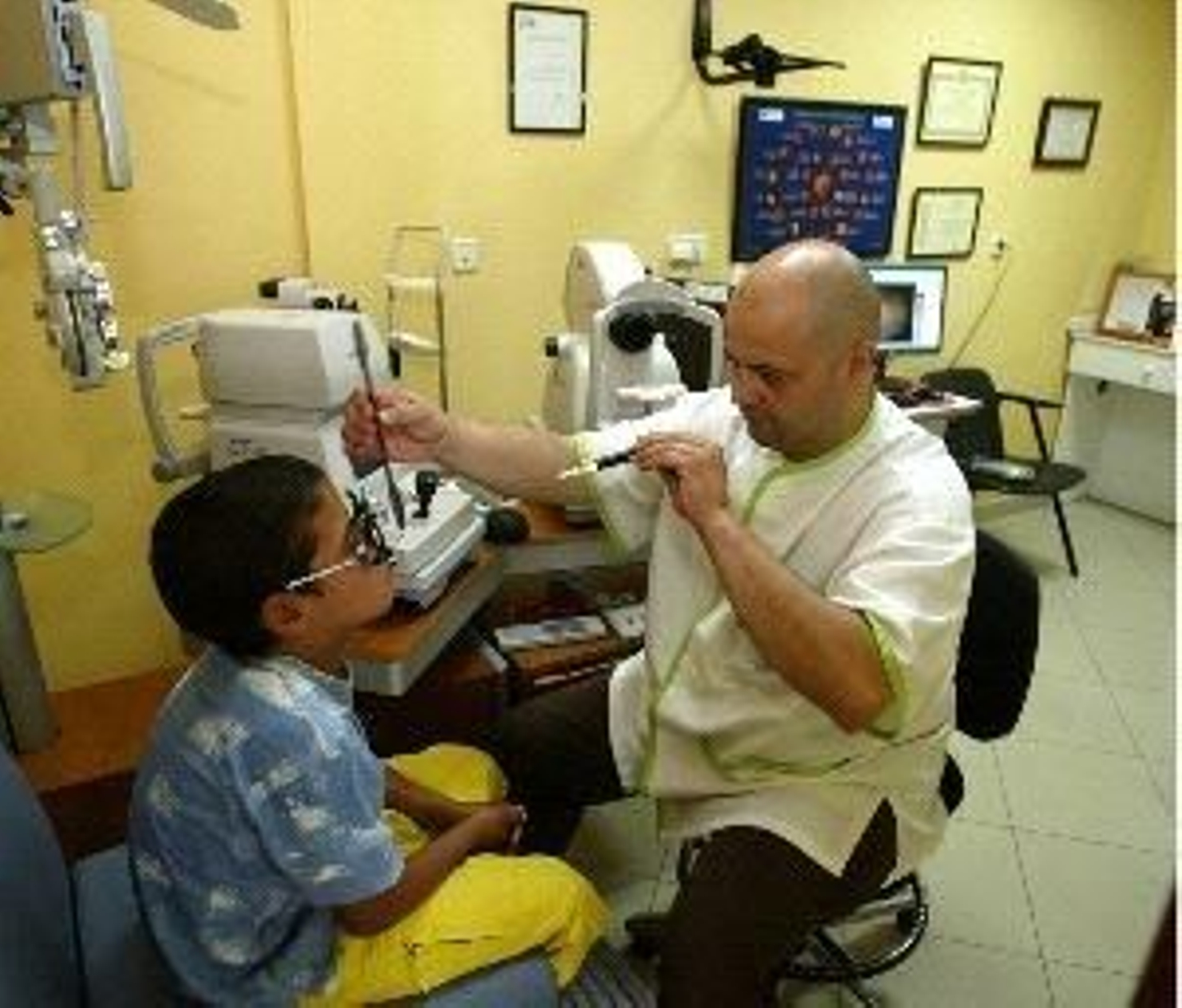 Un óptico realiza una revisión a un niño.