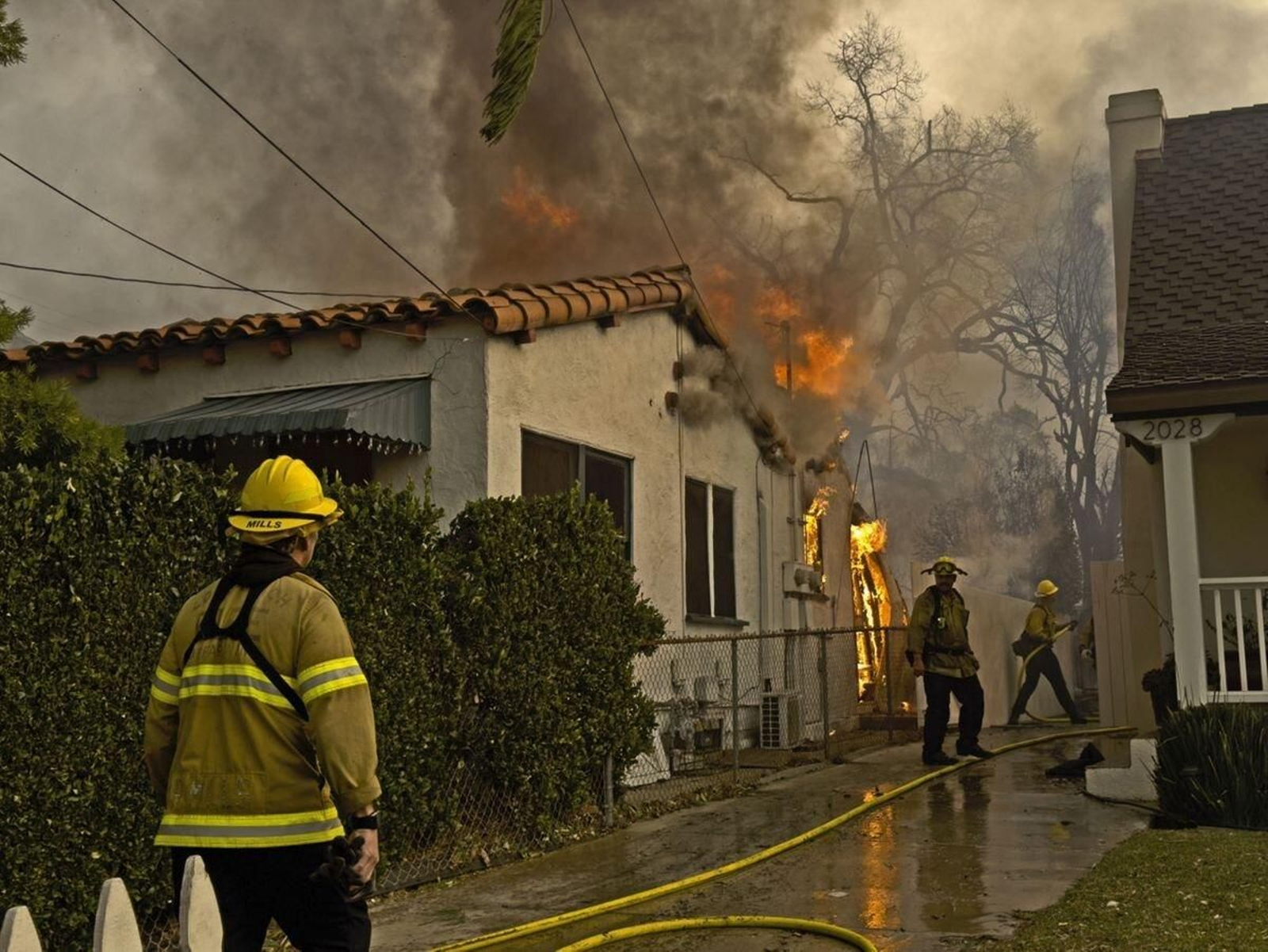 Los bomberos intentan apagar el fuego en una casa de Altadena, en California.