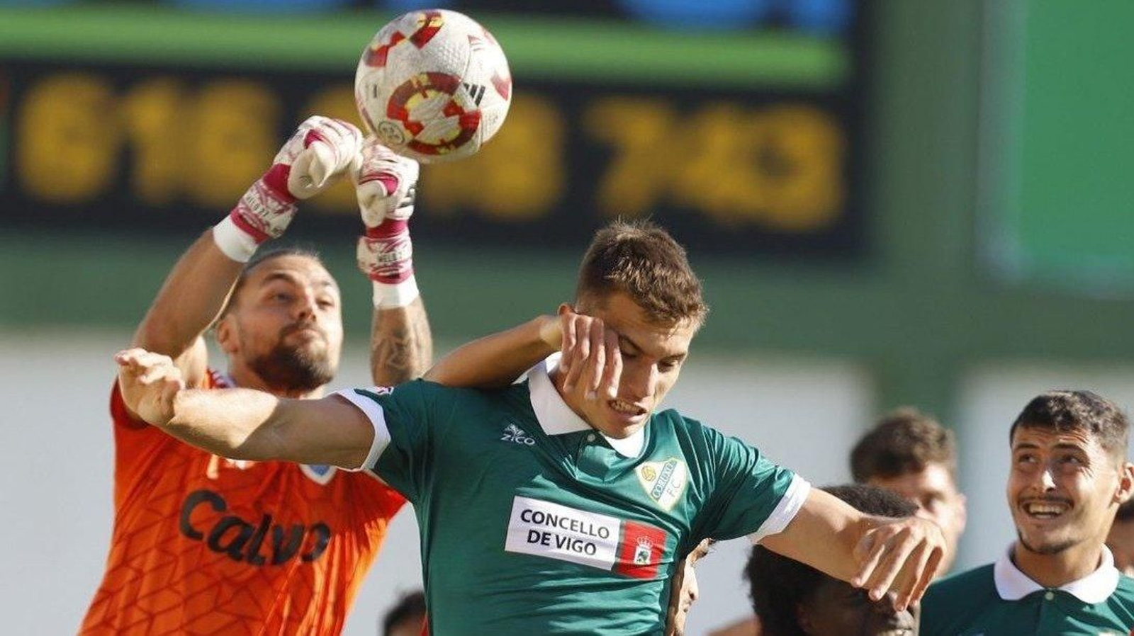 El meta visitante Santi Canedo sale de puños y despeja ante el salto del coruxista Guido.